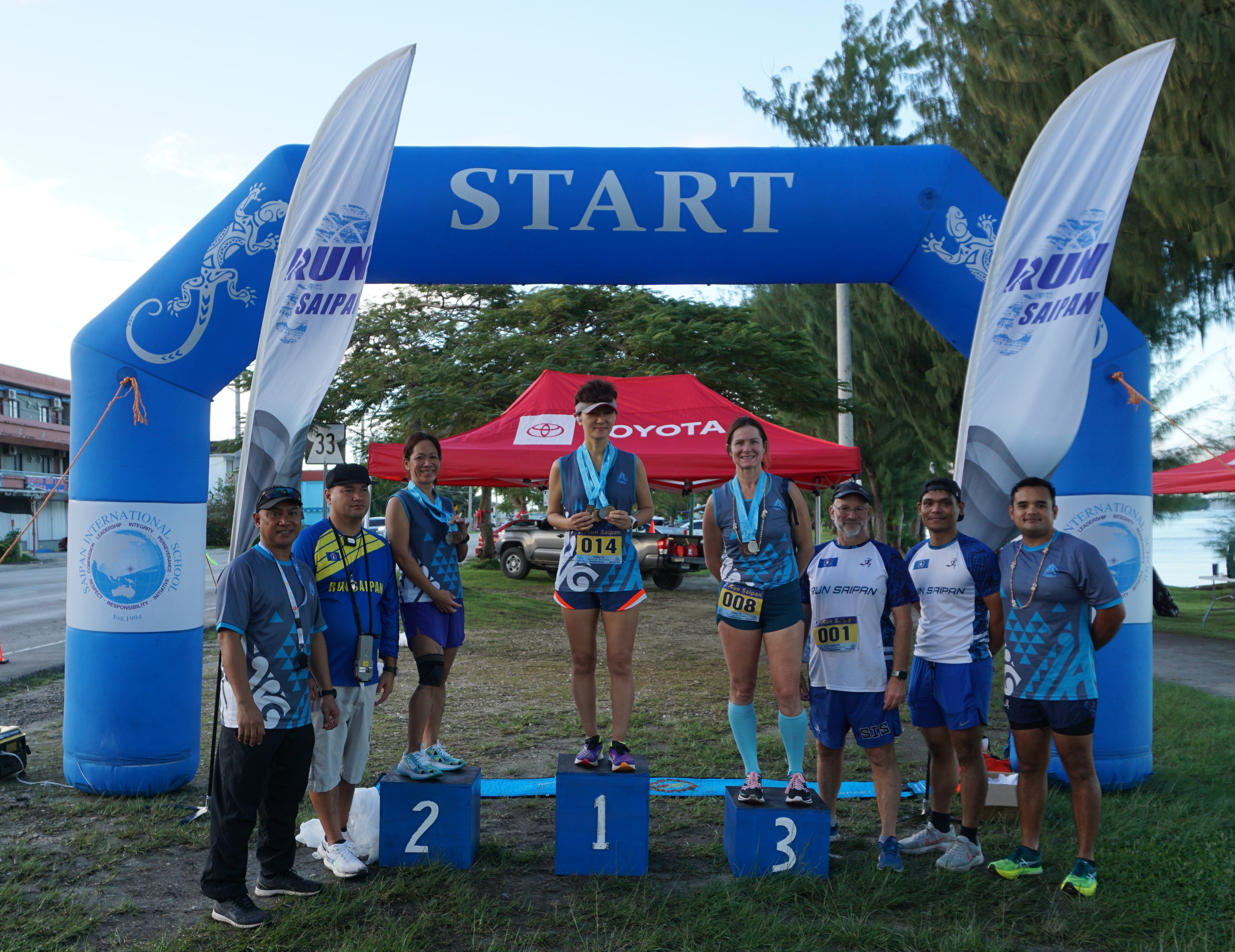 The top three women runners — Ann Bang, Rosemarie Chisato and Terra Allen — pose with Run Saipan officials during the awards ceremony Monday on Beach Road in Oleai.