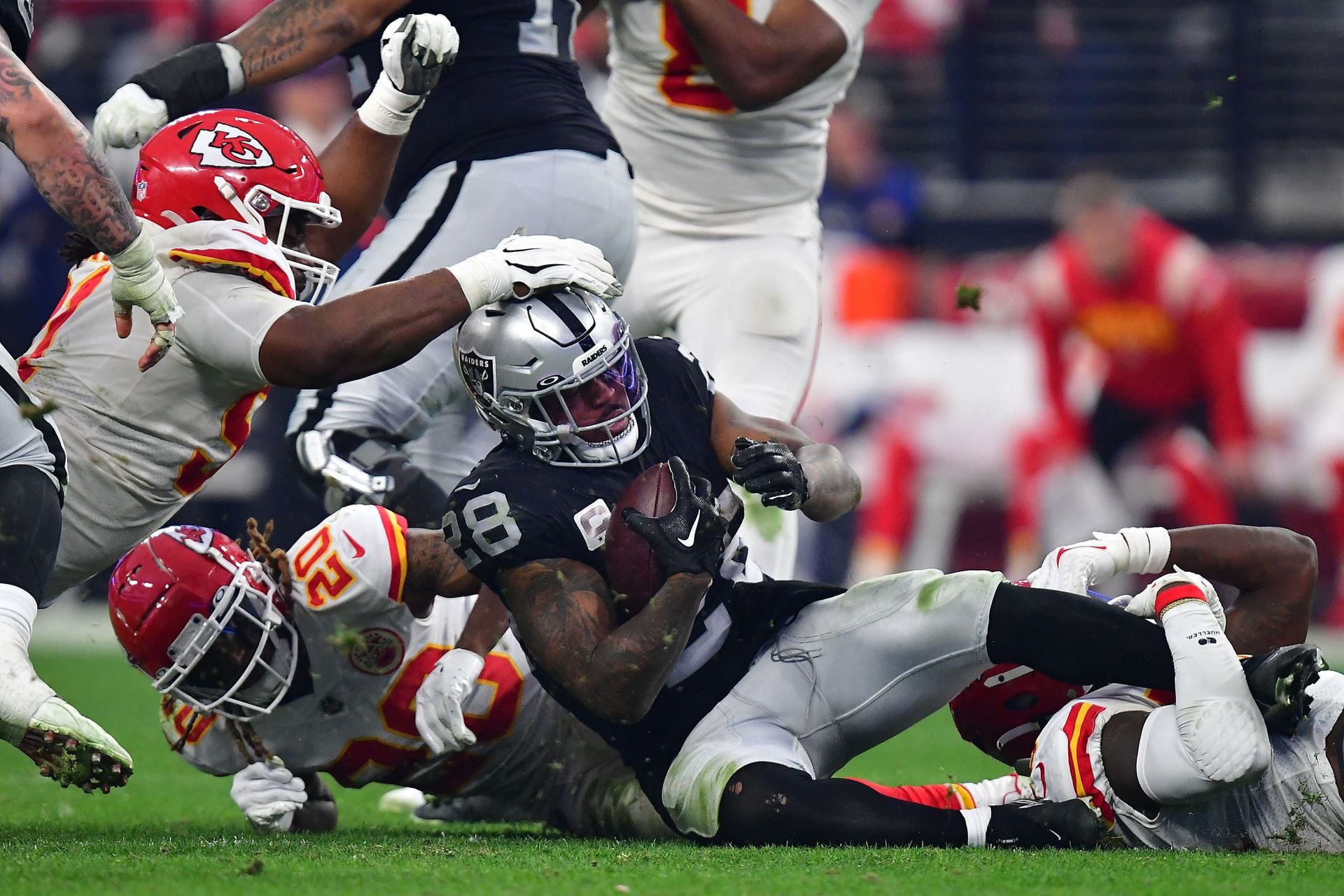 Las Vegas Raiders running back Josh Jacobs (28) is brought down by the Kansas City Chiefs defense during the second half at Allegiant Stadium in Paradise, Nevada, Jan. 7, 2023.