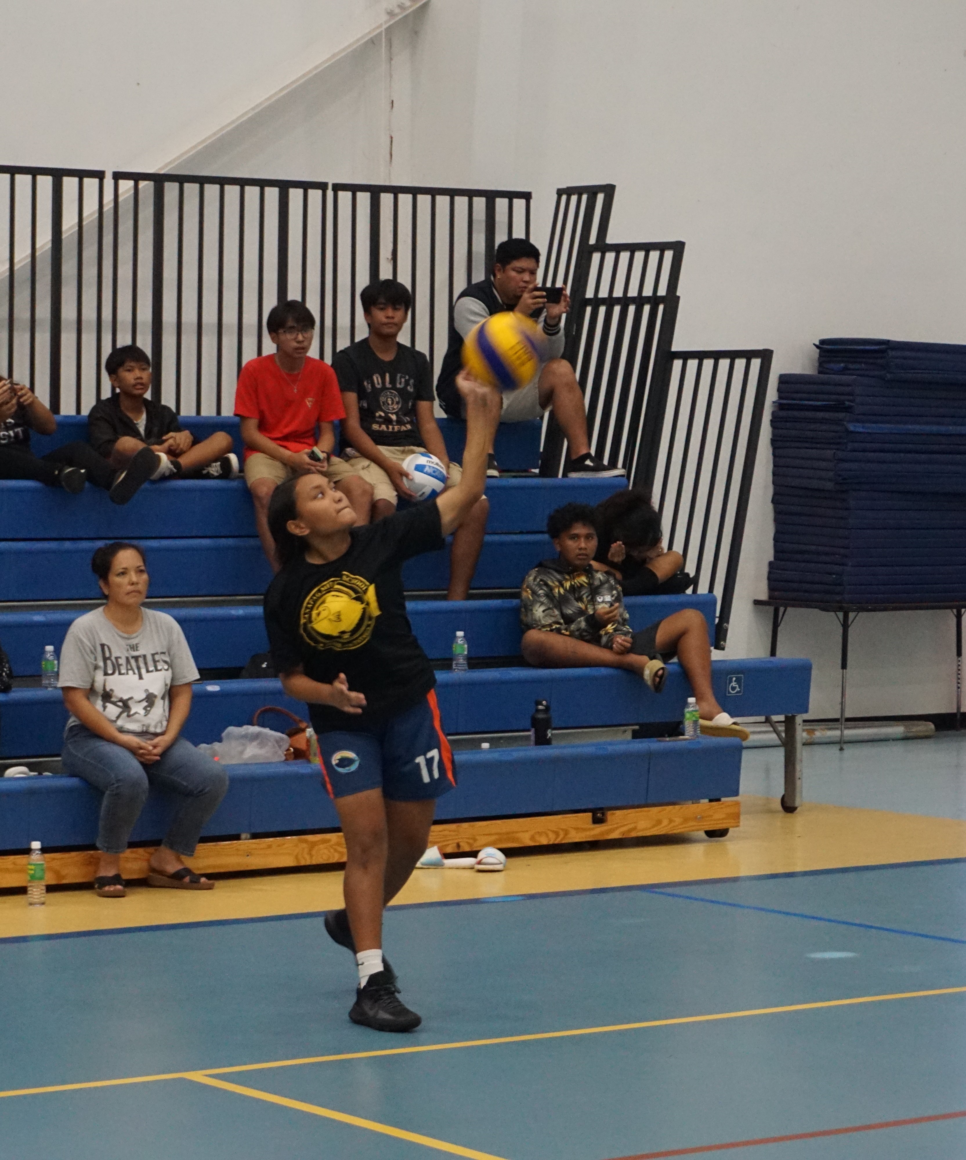 A TMS player connects a powerful overhead serve.