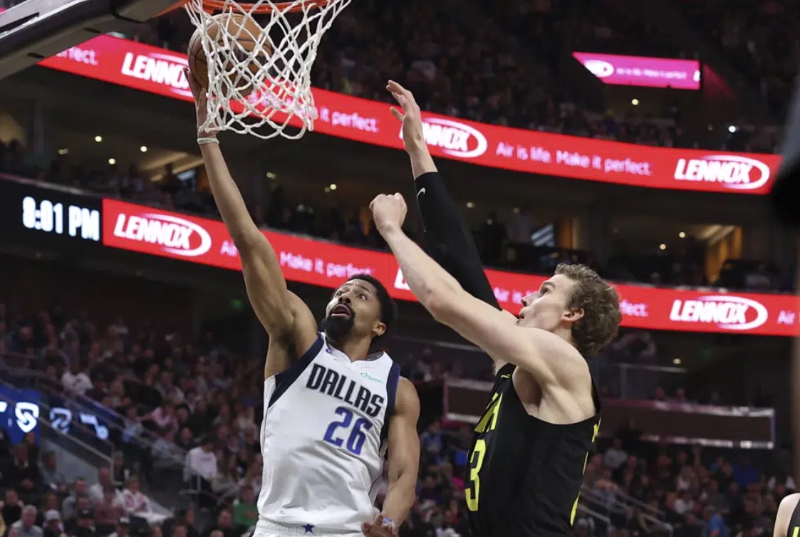 Dallas Mavericks guard Spencer Dinwiddie (26) lays up the ball against Utah Jazz forward Lauri Markkanen, right, in the first half of an NBA basketball game Saturday, Jan. 28, 2023, in Salt Lake City.