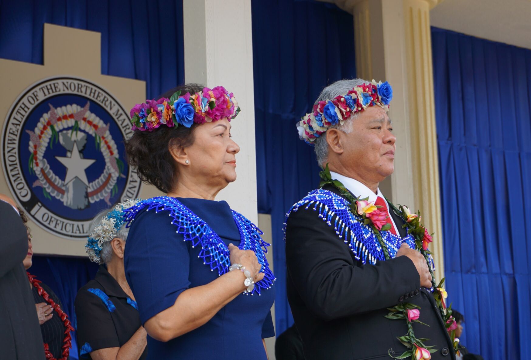 Gov. Arnold I. Palacios and first lady Wella S. Palacios place their right hands over their hearts for the singing of the national anthem.