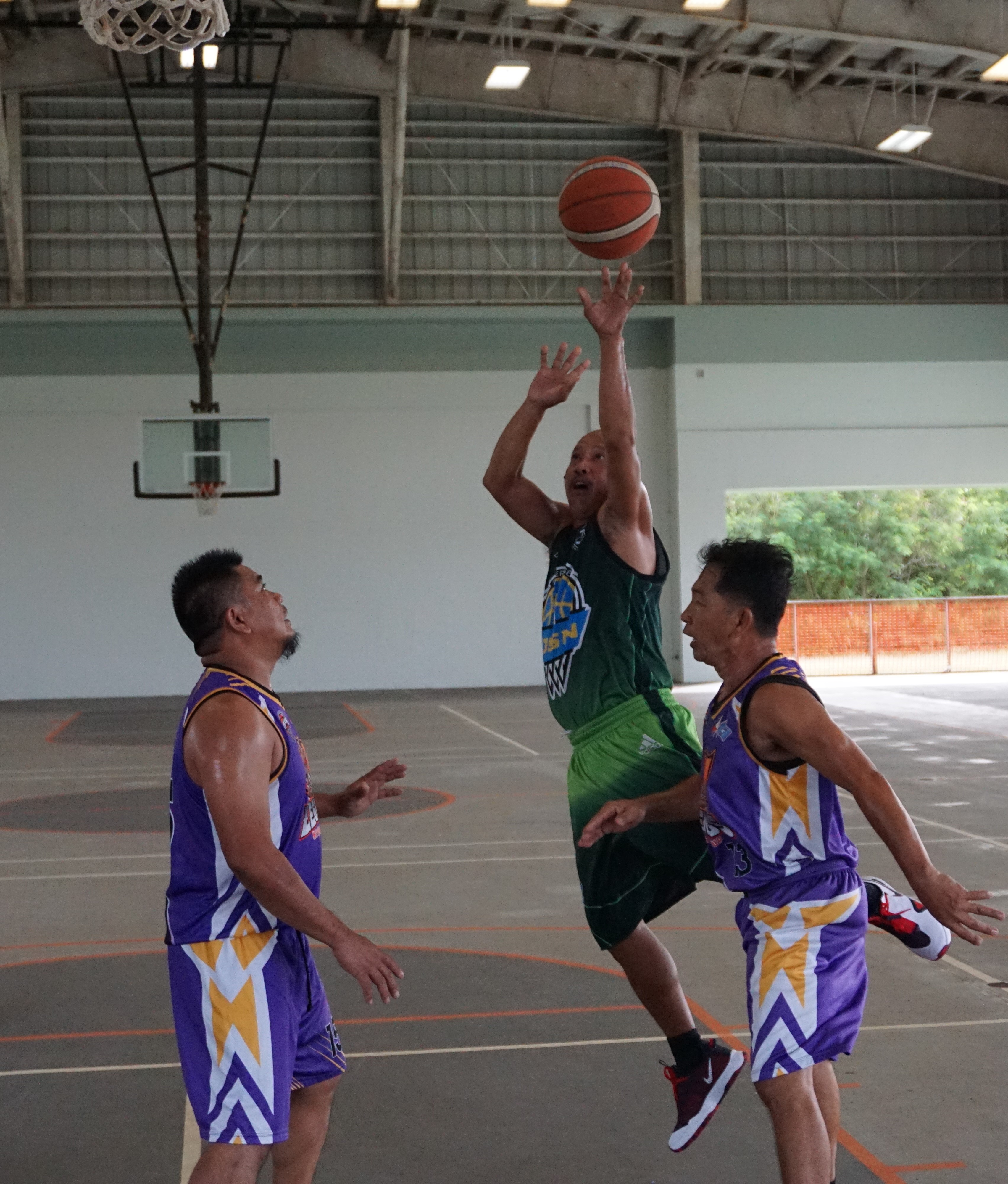 JSN Construction's Bernard Montano gets fouled as he takes the jump shot during a semifinal game Sunday in the masters division of the Legends Sports Association Invitational Basketball League at Koblerville gym.