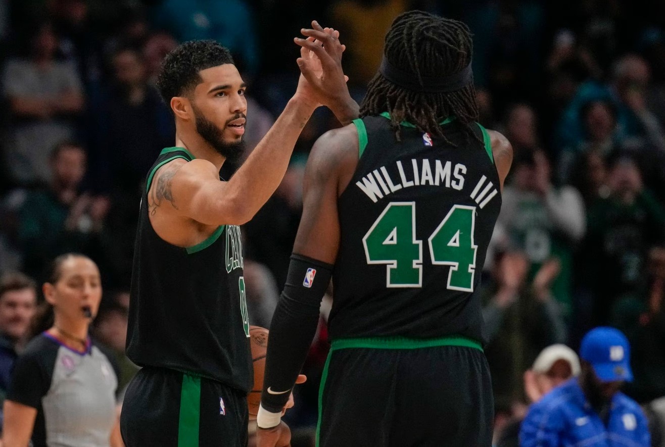Boston Celtics forward Jayson Tatum (0) high fives center Robert Williams III (44) as time ends during the second half against the Charlotte Hornets at Spectrum Center in Charlotte, North Carolina, Jan. 16, 2023.