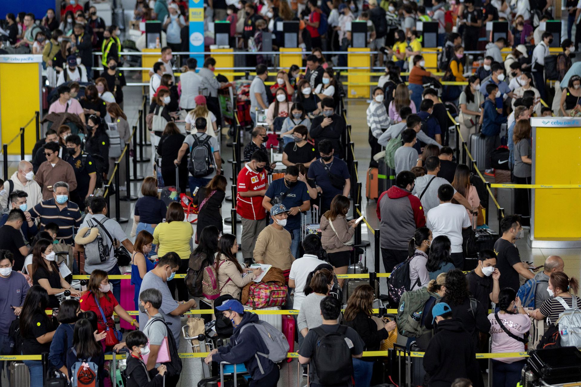 Passengers queue at an airline counter in the Ninoy Aquino International Airport, in Pasay City, Metro Manila, the Philippines, Jan. 2, 2023.