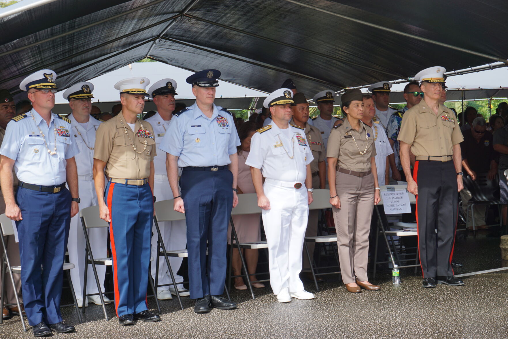 U.S. military officials led by Rear Adm. Benjamin Nicholson, Joint Region Marianas commander, 3rd right, front row, stand at attention during the singing of the CNMI anthem prior to the swearing in of Gov. Arnold I. Palacios and Lt. Gov. David M. Apatang on Monday, Jan. 9, 2023 at the multi-purpose center in Susupe, Saipan. 