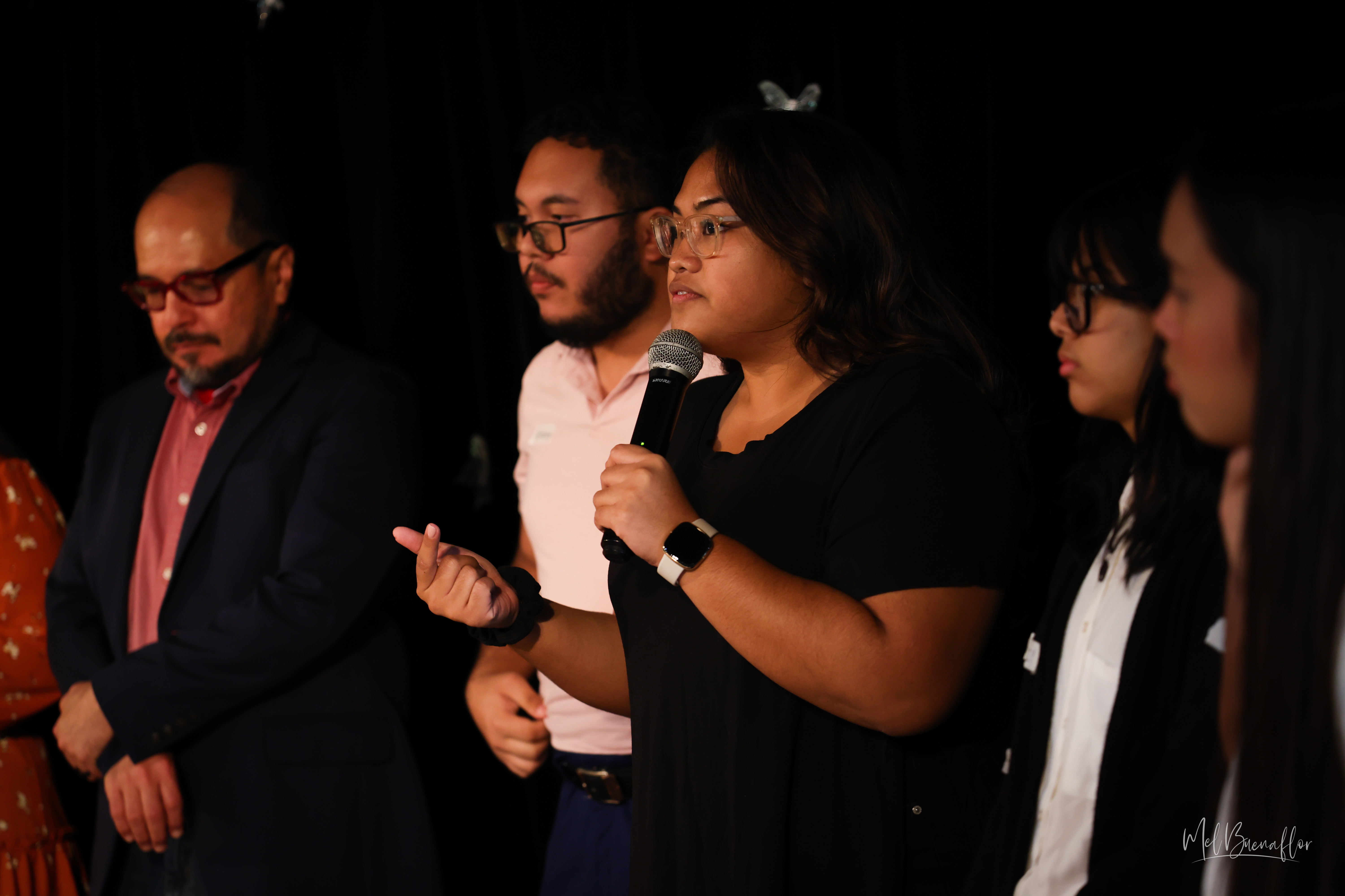 Affectionately called by students the Single Letter Mentors for “V,” “Z,” and “G,” AlumKnights and Theatre Club veterans/advisers Victoria Deleon Guerrero, center, Zeno Deleon Guerrero, left of center, and Galvin Deleon Guerrero, far left, lead students in a prayer before the start of the show.