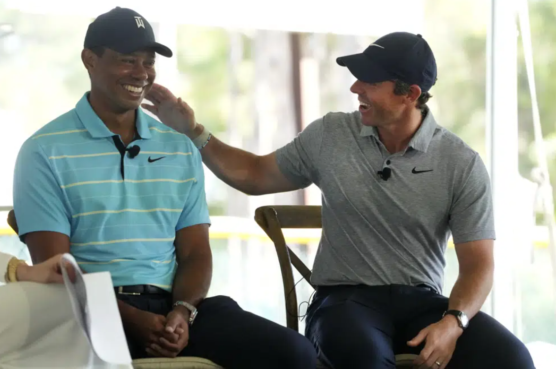 Golfers Tiger Woods, left, and Rory McIlroy share a laugh as they discuss the future home of their tech-infused golf league that will begin play next year, Tuesday, Feb. 21, 2023, on the campus of Palm Beach State College in Palm Beach Gardens, Fla.