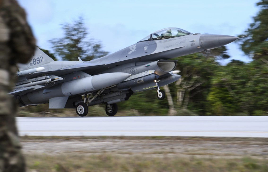 U.S. Air Force Airmen watch as a U.S. Air Force F-16 Fighting Falcon assigned to the 35th Fighter Wing from Misawa Air Base, Japan, lands during exercise Cope North 22 on Northwest Field, Guam, Feb. 4, 2022.