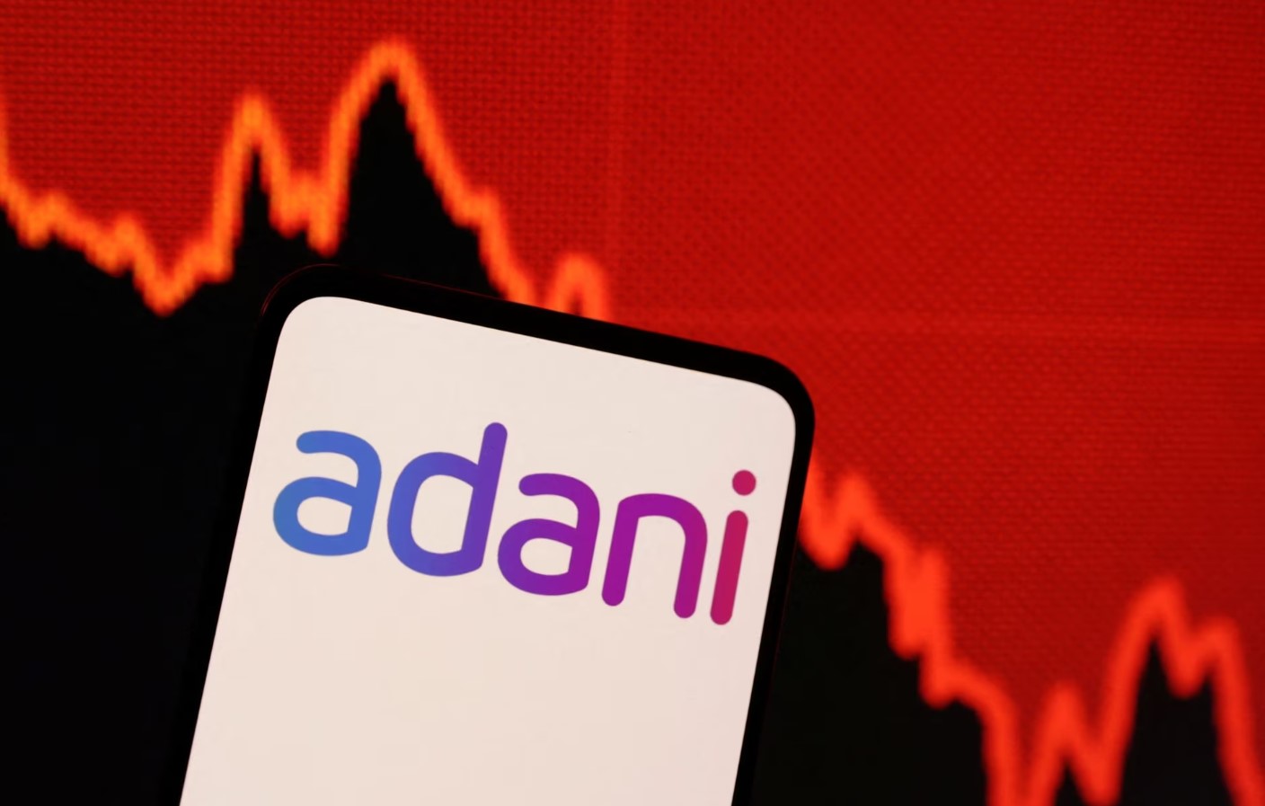 Adani logo and decreasing stock graph is seen in this illustration taken on Jan. 31, 2023.