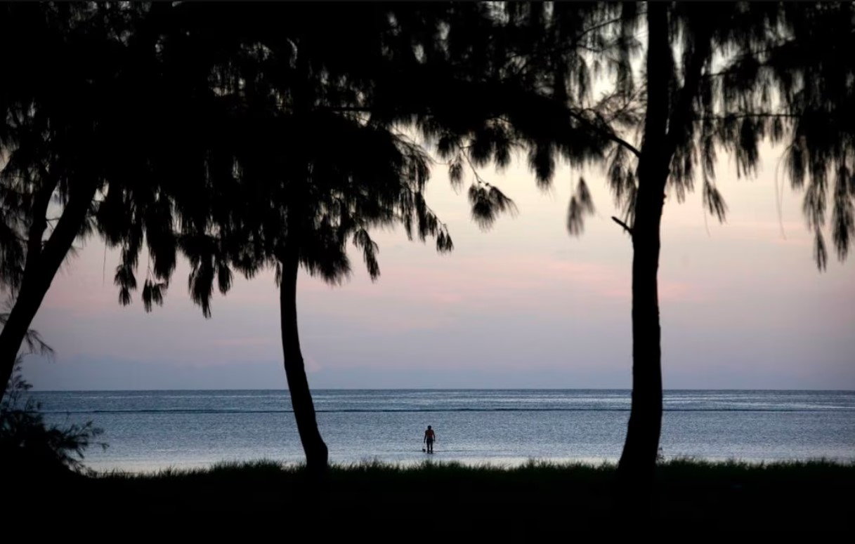 A fisherman wades in shallow water at the shoreline near the village of Tangintebu on South Tarawa in the central Pacific island nation of Kiribati, May 25, 2013.