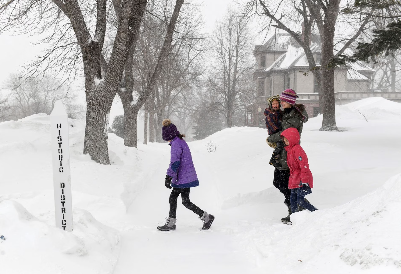 The Motz family walks through blowing snow as weather conditions worsen in Sioux Falls, South Dakota, Feb. 22, 2023.