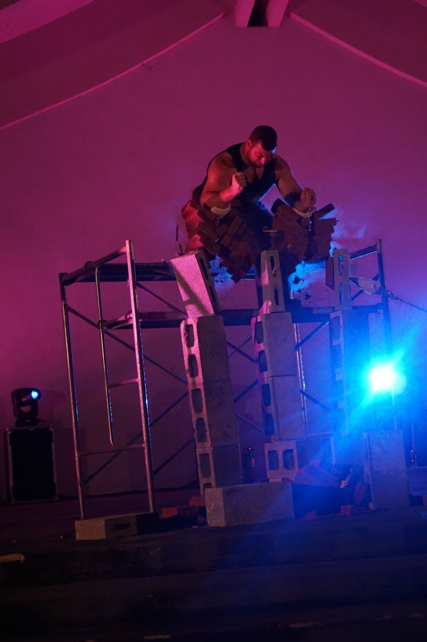 Power Team member Matt Reed breaks bricks with his forearms.
