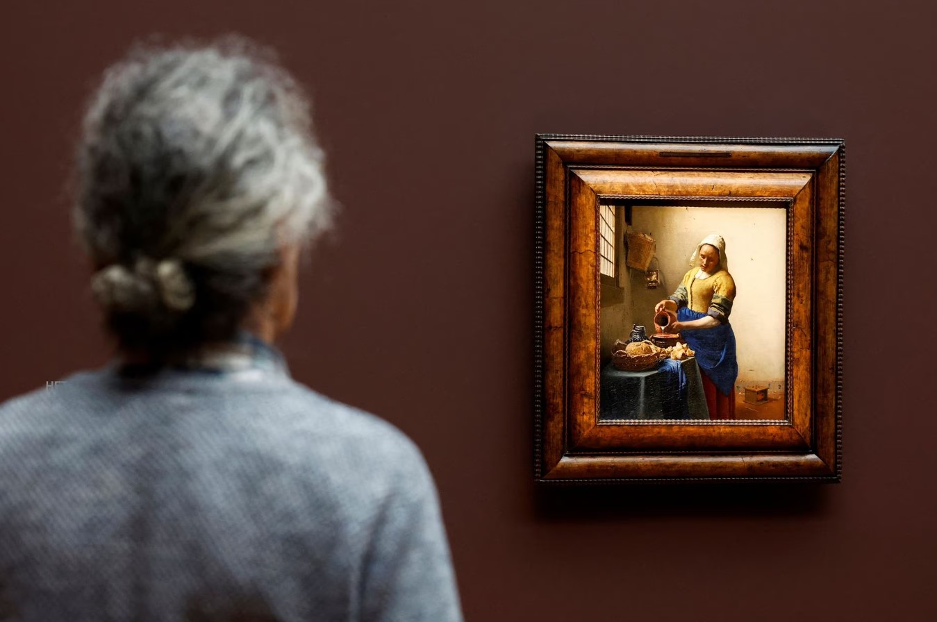 A man looks at Vermeer's painting “The Milkmaid” at an exhibition bringing together 28 works by Dutch painter Johannes Vermeer at the Rijksmusuem in Amsterdam, the Netherlands, Feb. 6, 2023.