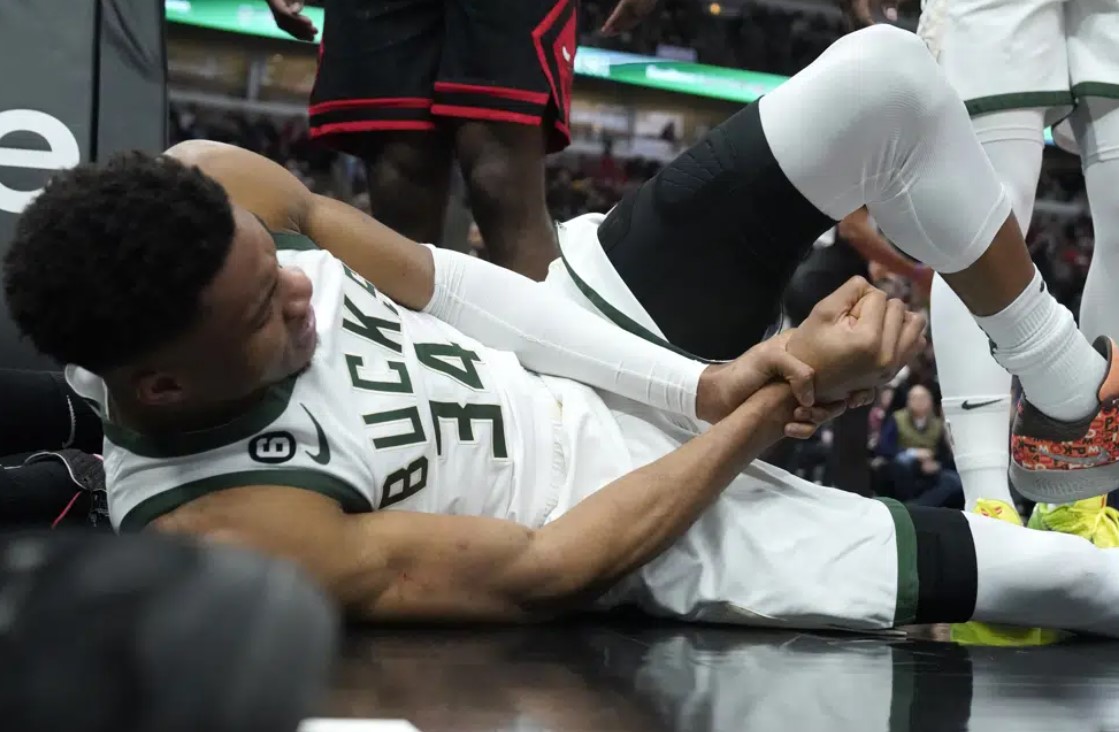 Milwaukee Bucks' Giannis Antetokounmpo lies by the basket after injuring his right wrist during the first half of the team's NBA basketball game against the Chicago Bulls on Thursday, Feb. 16, 2023, in Chicago.