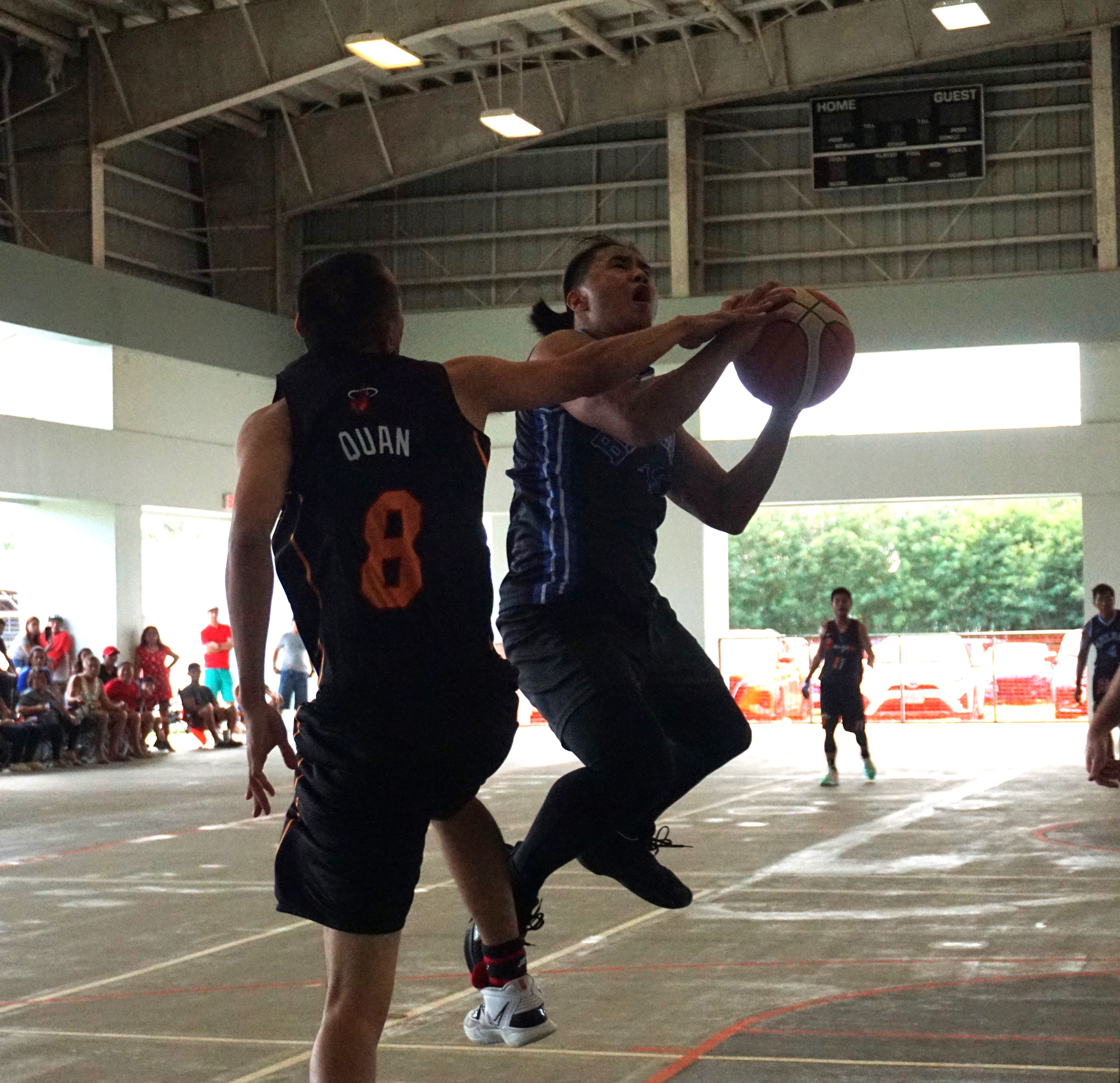 Blue Haus's Ivan De Vero gets fouled as he goes up for the shot during the open division championship game of the Legends Sports Association Invitational Basketball League at the Koblerville gym on Sunday.