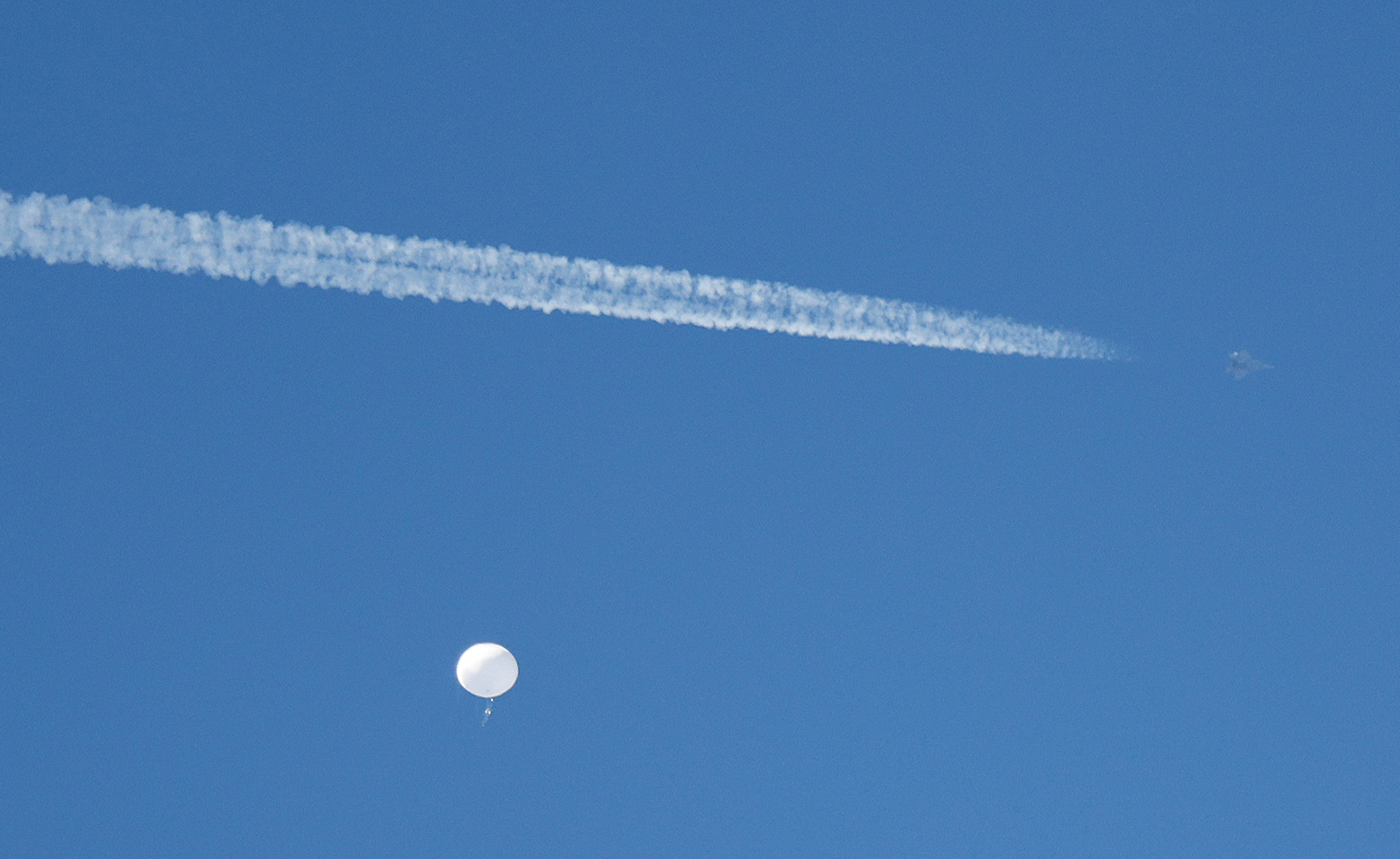 A jet flies by a suspected Chinese spy balloon as it floats off the coast in Surfside Beach, South Carolina, Feb. 4, 2023.