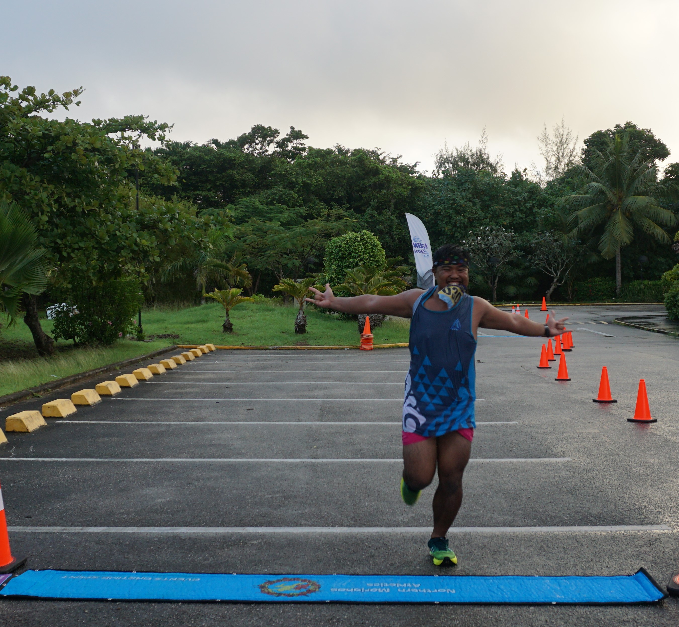 Simon Necesito celebrates as he crosses the finish line and steps on the ONETIME timing mat used during  Run Saipan’s Trinity event last month in the Kensington Hotel parking lot.