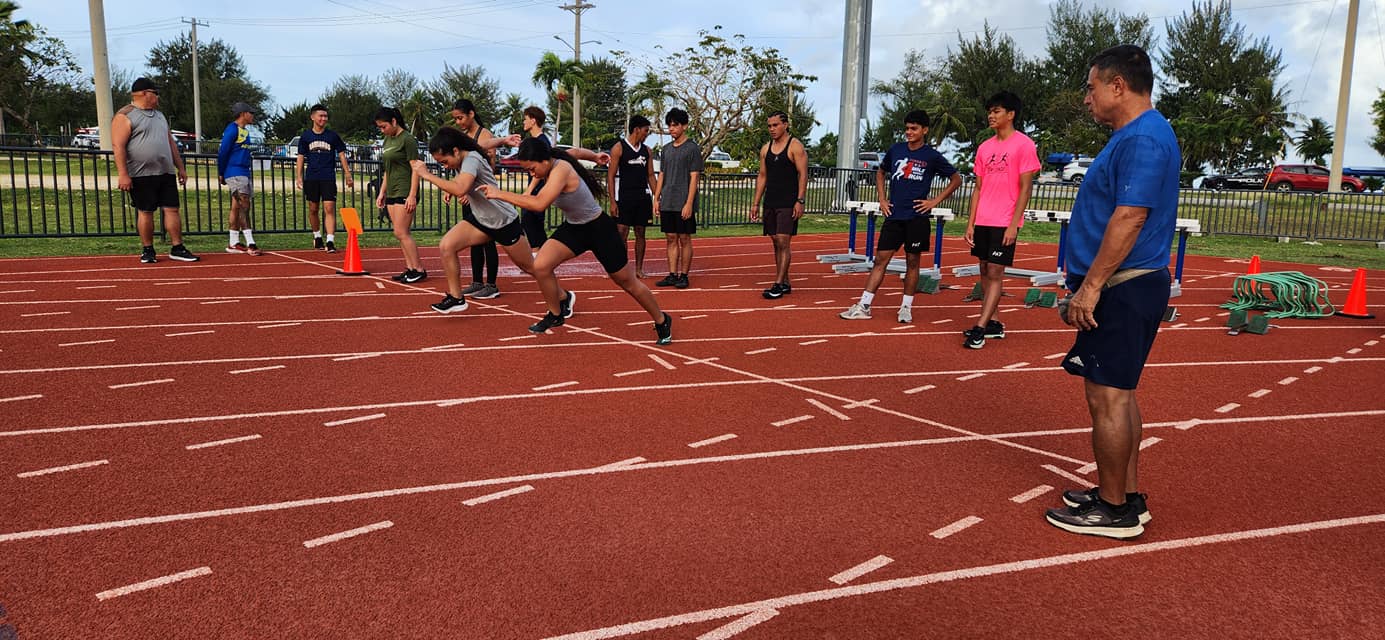 Northern Marianas Athletics Development Officer Elias Rangamar, right, looks on as participants perform sprinting drills during week 2 of the NMA Talent ID Camp at the track & field of the Oleai Sports Complex on  Saturday.