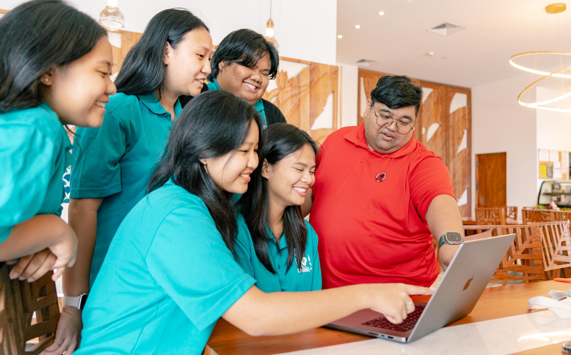 Robert Camacho Suzuki Jr., right, an extension agent with the NMC-CREES Family, Community, and Youth Development Program, provides guidance and mentorship to a group of 4-H volunteers, helping them to develop new skills and leadership qualities.