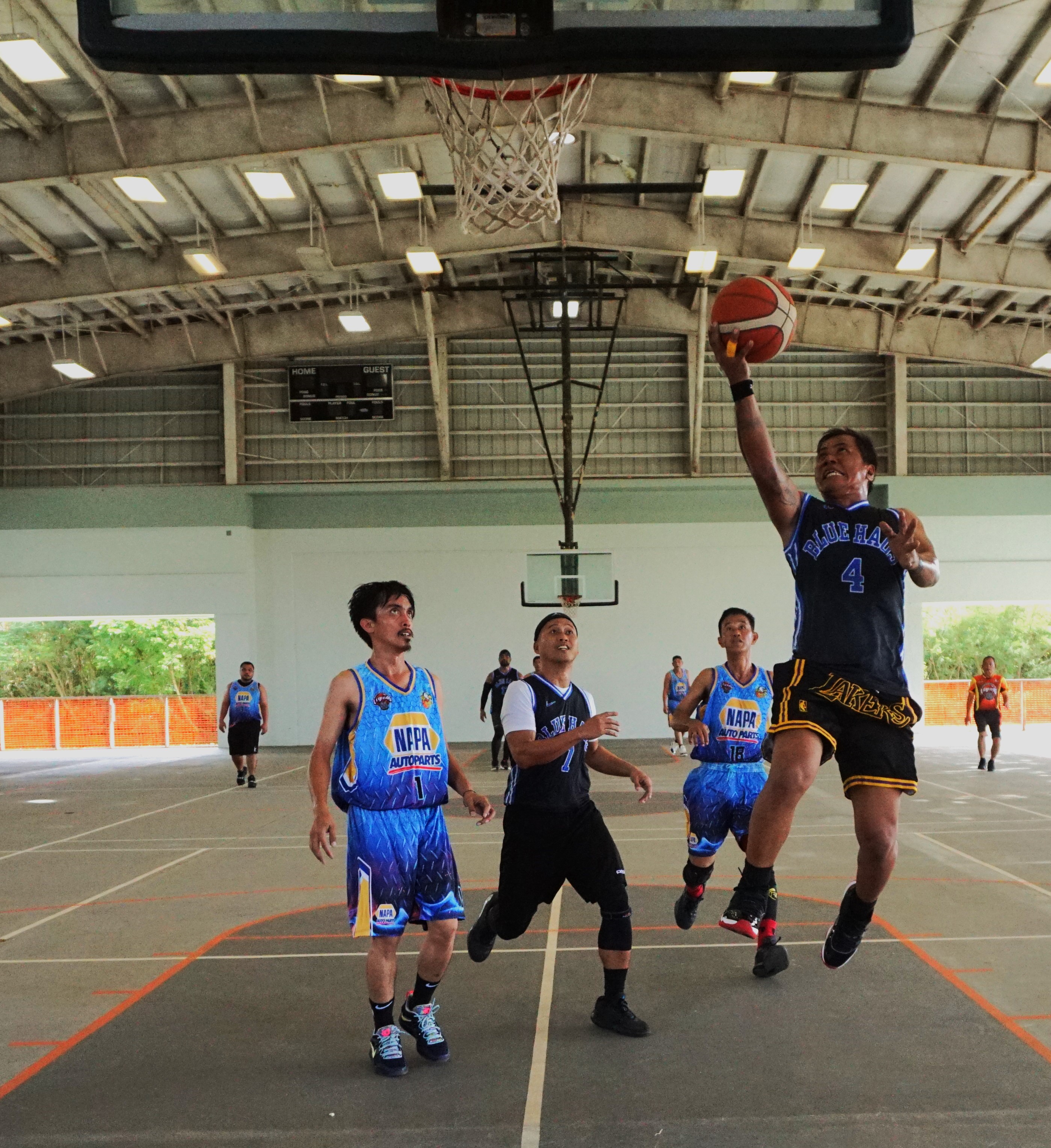 Blue Haus' Brendon Talania extends for the fastbreak finish during an open division semifinal game of the Legends Sports Association Invitational Basketball League on Saturday at the Koblerville gym.