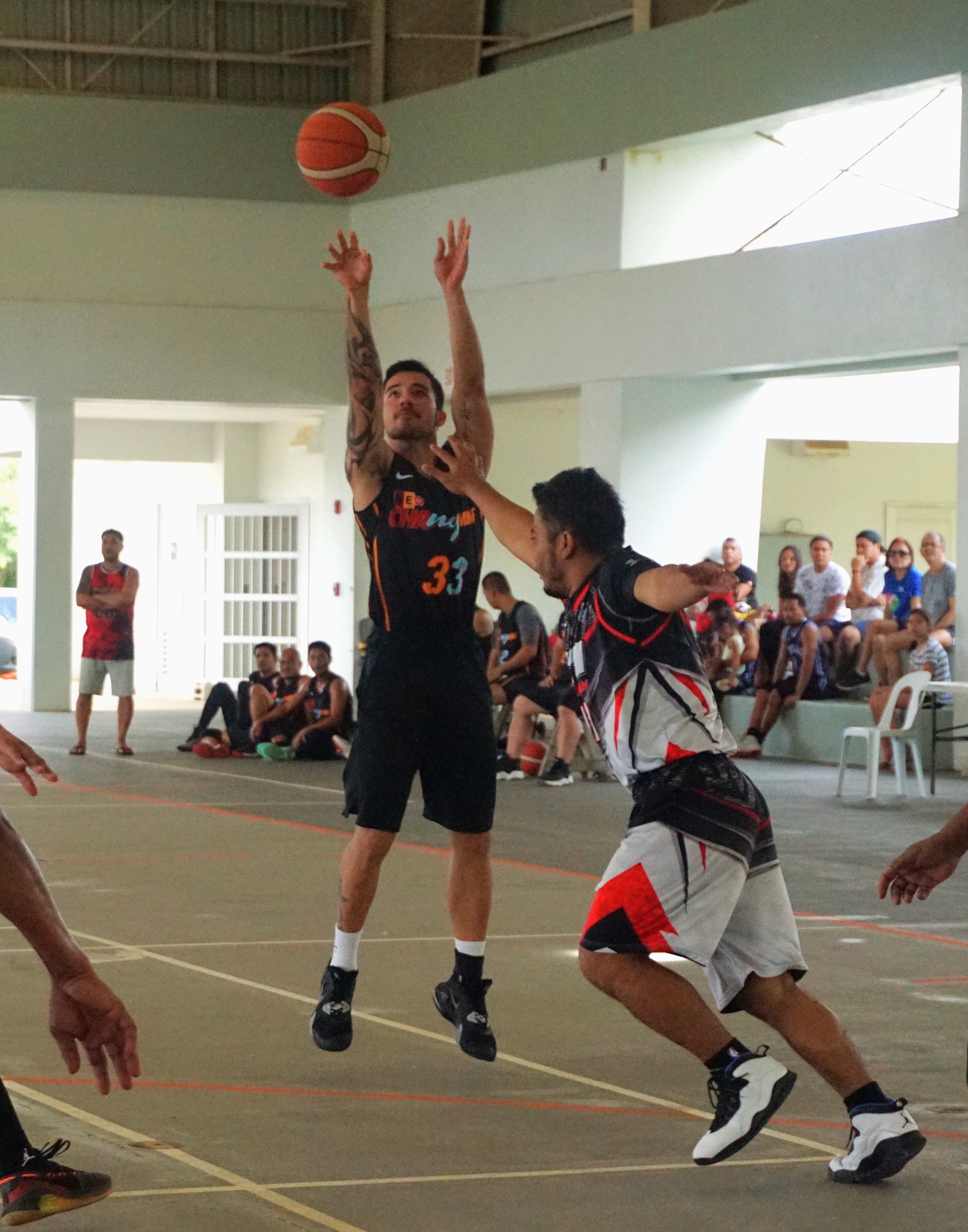 Chang Ming Market's Don Brennan takes the contested three-point shot during an open division semifinal game of the Legends Sports Association Invitational Basketball League on Saturday at the Koblerville gym.