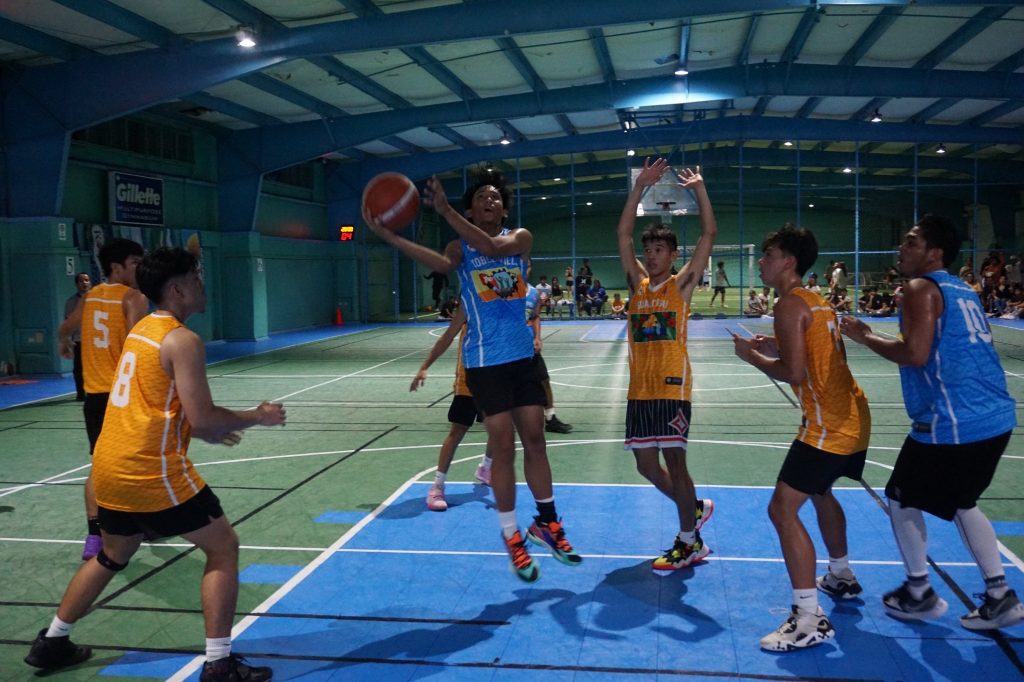 U18 Koblerville's Justin Mateo leans for the double-clutch layup.