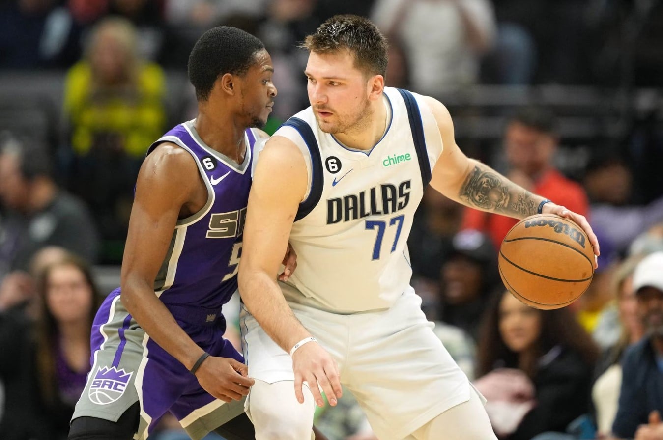 Dallas Mavericks guard Luka Doncic (77) dribbles against Sacramento Kings guard De'Aaron Fox (5) during the fourth quarter at Golden 1 Center in Sacramento, California, Feb. 11, 2023.