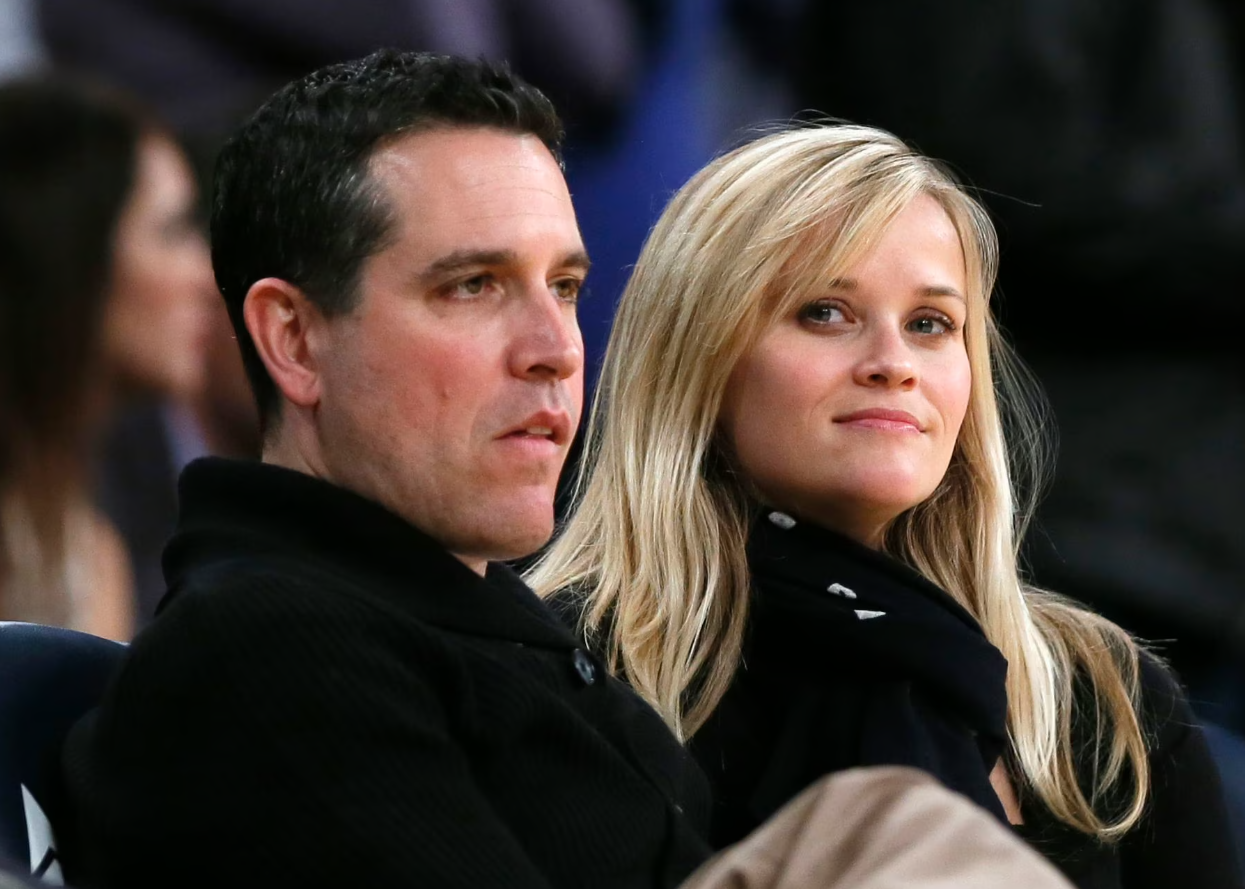 Reese Witherspoon, right, and her husband Jim Toth watch the Toronto Raptors play the Los Angeles Lakers in their NBA basketball game in Los Angeles, March 8, 2013.