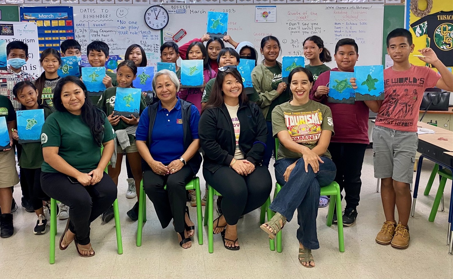 Marianas Tourism Education Council Board Chairwoman Vicky Benavente, seated second left, leads an educational outreach to the MY WAVE —  Marianas Youth Welcome All Visitors Enthusiastically — Club of Oleai Elementary on March 6, 2023, in Saipan. Standing are MY WAVE Club members and seated, from left, are MY WAVE Club Advisor Mildred Kintol, Benavente, MY WAVE Club Advisor Mayuko Arriola, and MTEC Board Member Catherine Perry.  Not pictured are club advisors Don Felix Taisacan and Jake Reyes.