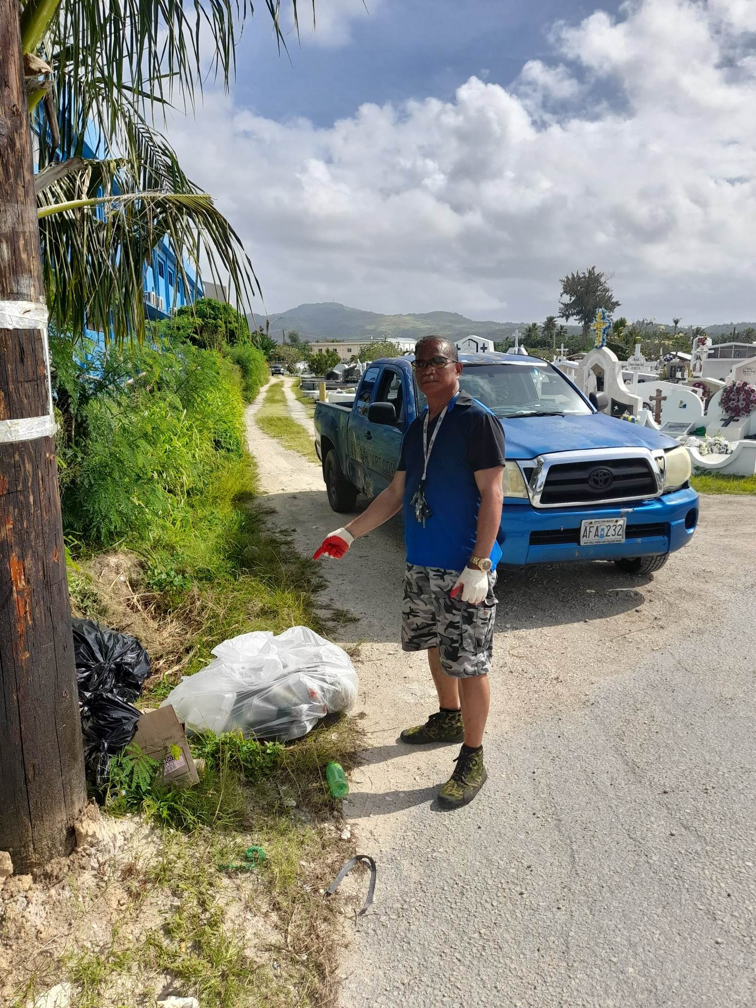 Max Aguon points to the trash that was disposed improperly at the Chalan Kanoa cemetery.