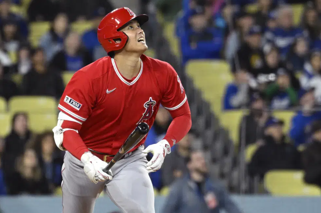 Los Angeles Angels' Shohei Ohtani runs to first as he flies out during the sixth inning of a preseason baseball game against the Los Angeles Dodgers Sunday, March 26, 2023, in Los Angeles.