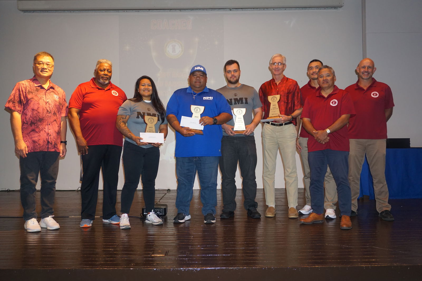 Coaches of the Year Antonette Labausa, Manny Sablan, David Barnhouse and Jeff Race hold their trophies while posing for a photo with Northern Marianas Sports Association President Jerry Tan and board members during the NMSA Awards Banquet at the Hibiscus Hall of Crowne Plaza Resort Saipan, Tuesday night.