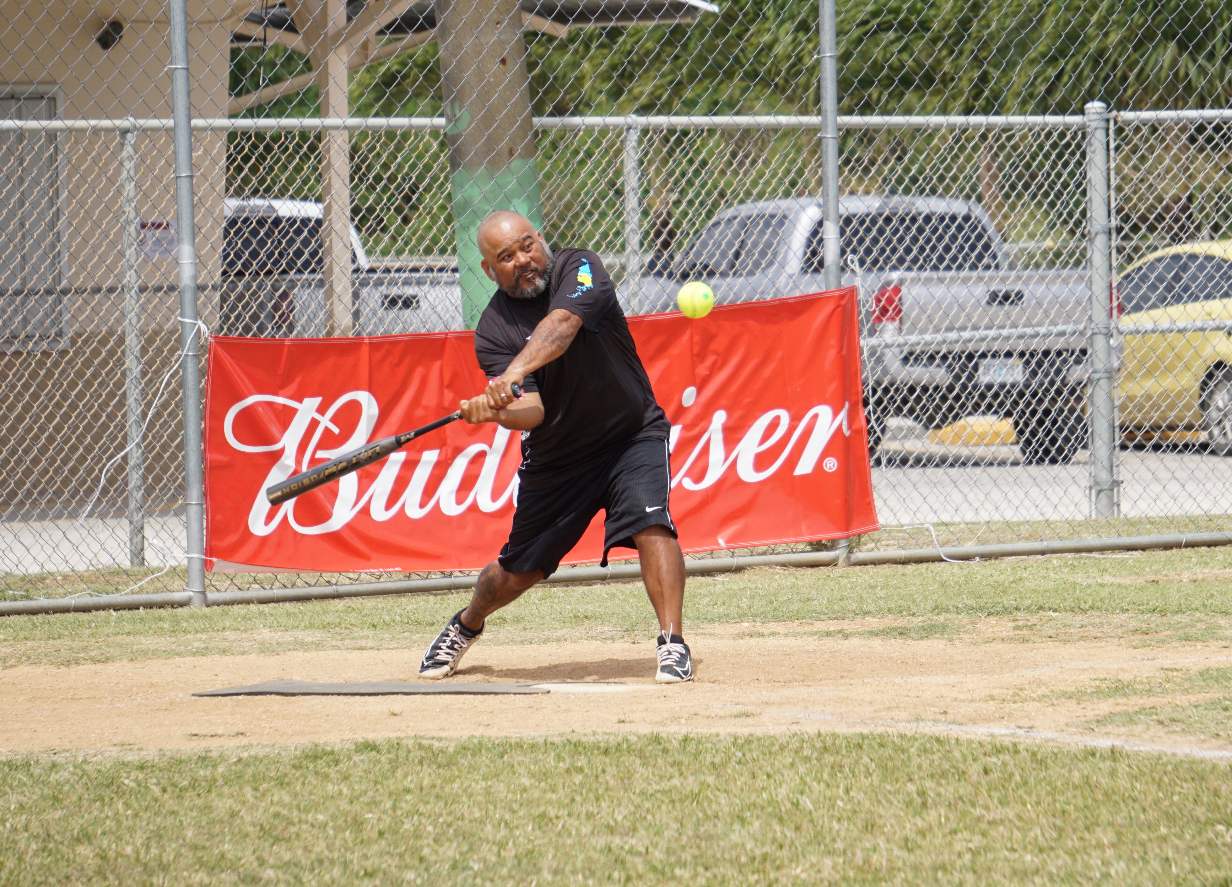 Asahi's Edgar Ito swings and connects during a 2023 Budweiser Belau Amateur Softball League  game Sunday at the Dandan baseball field.