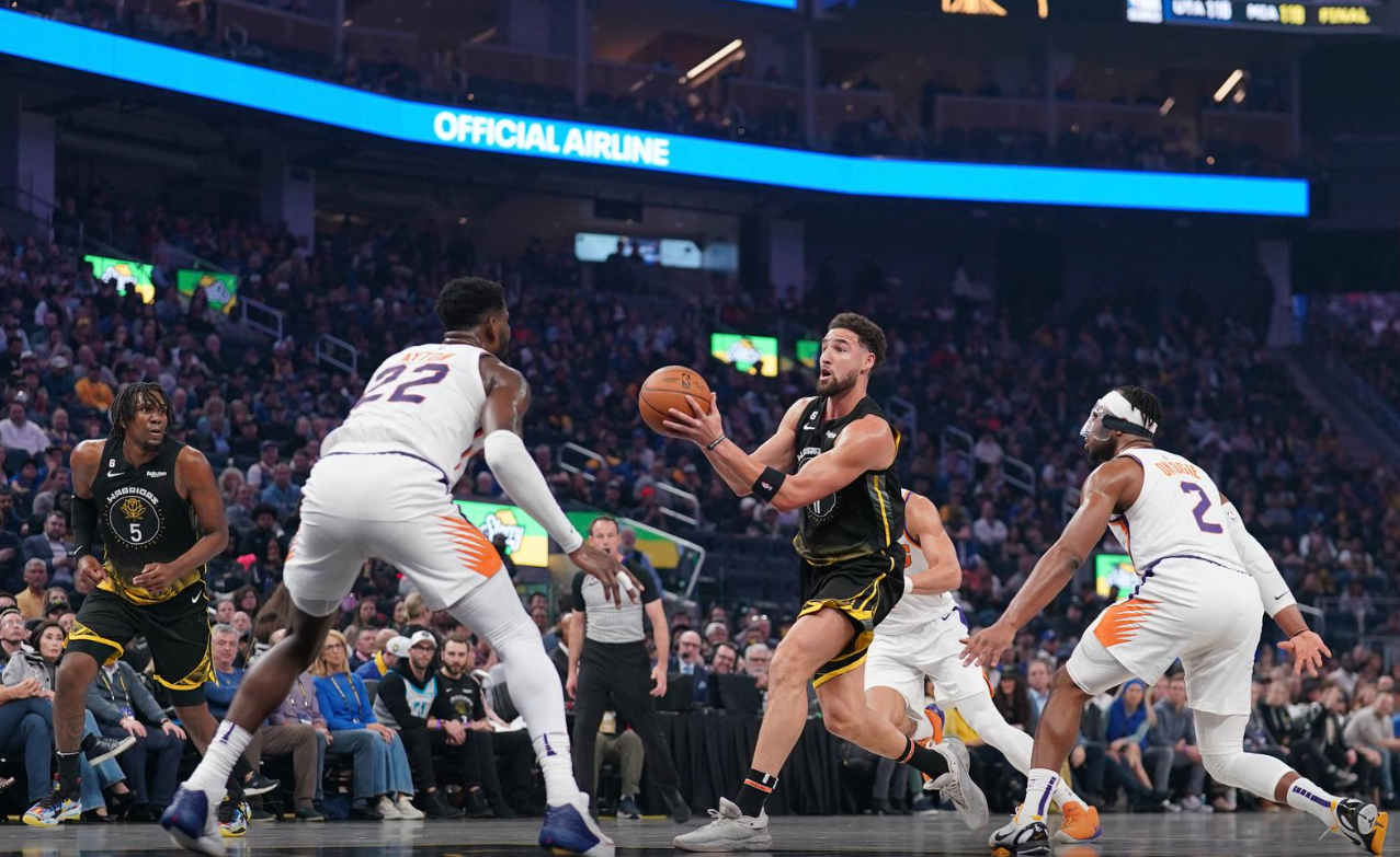 Golden State Warriors guard Klay Thompson (11) drives to the hoop between Phoenix Suns guard Josh Okogie (2) and Phoenix Suns center Deandre Ayton (22) in the first quarter at the Chase Center in San Francisco, California, March 13, 2023.