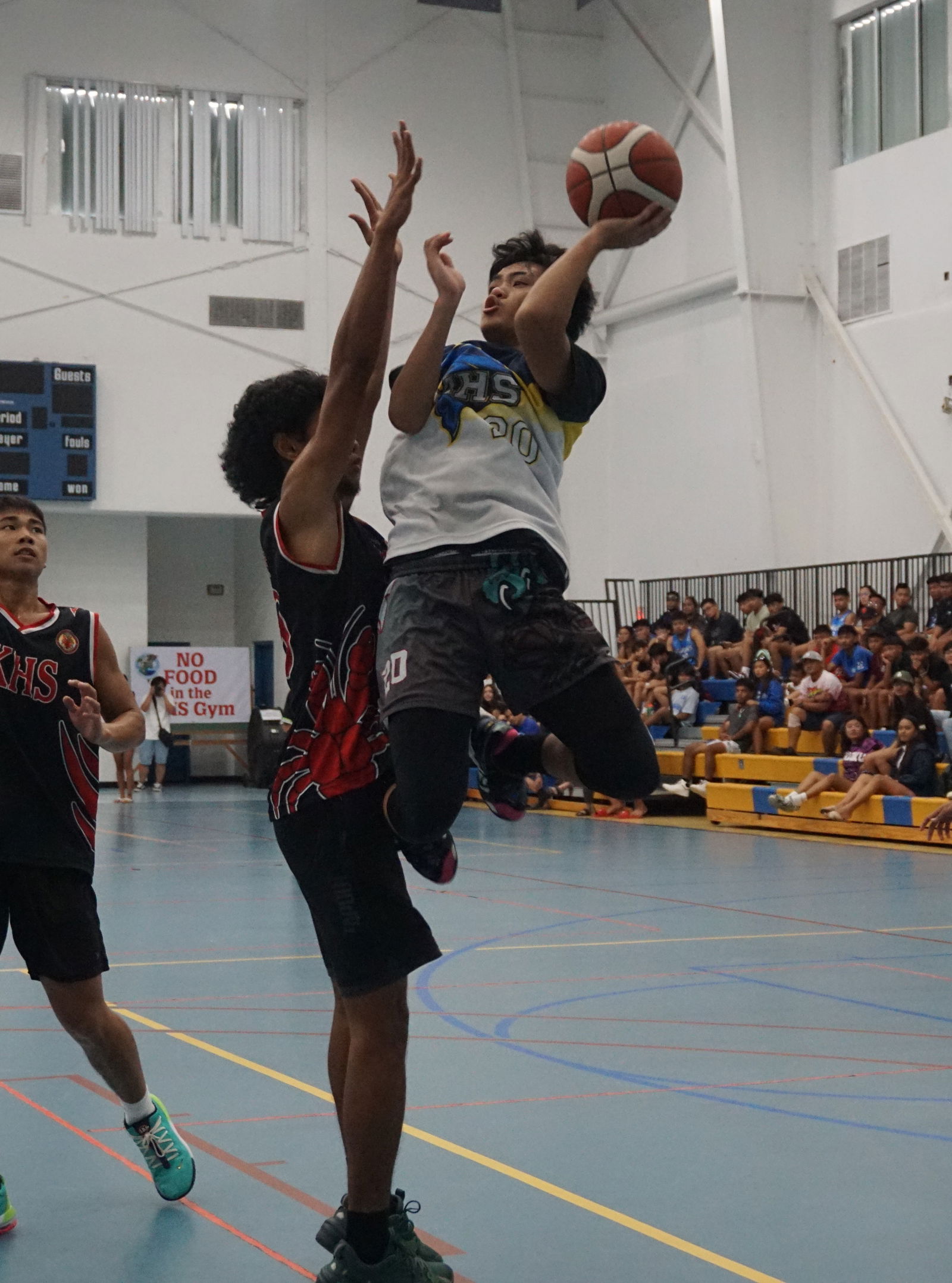 MHS' Aiden Suba takes the off-balanced one-handed shot against KHS' Frankie Satur during  the boys high school division championship game of the IT&E Interscholastic Basketball League on Saturday at the MHS gym.