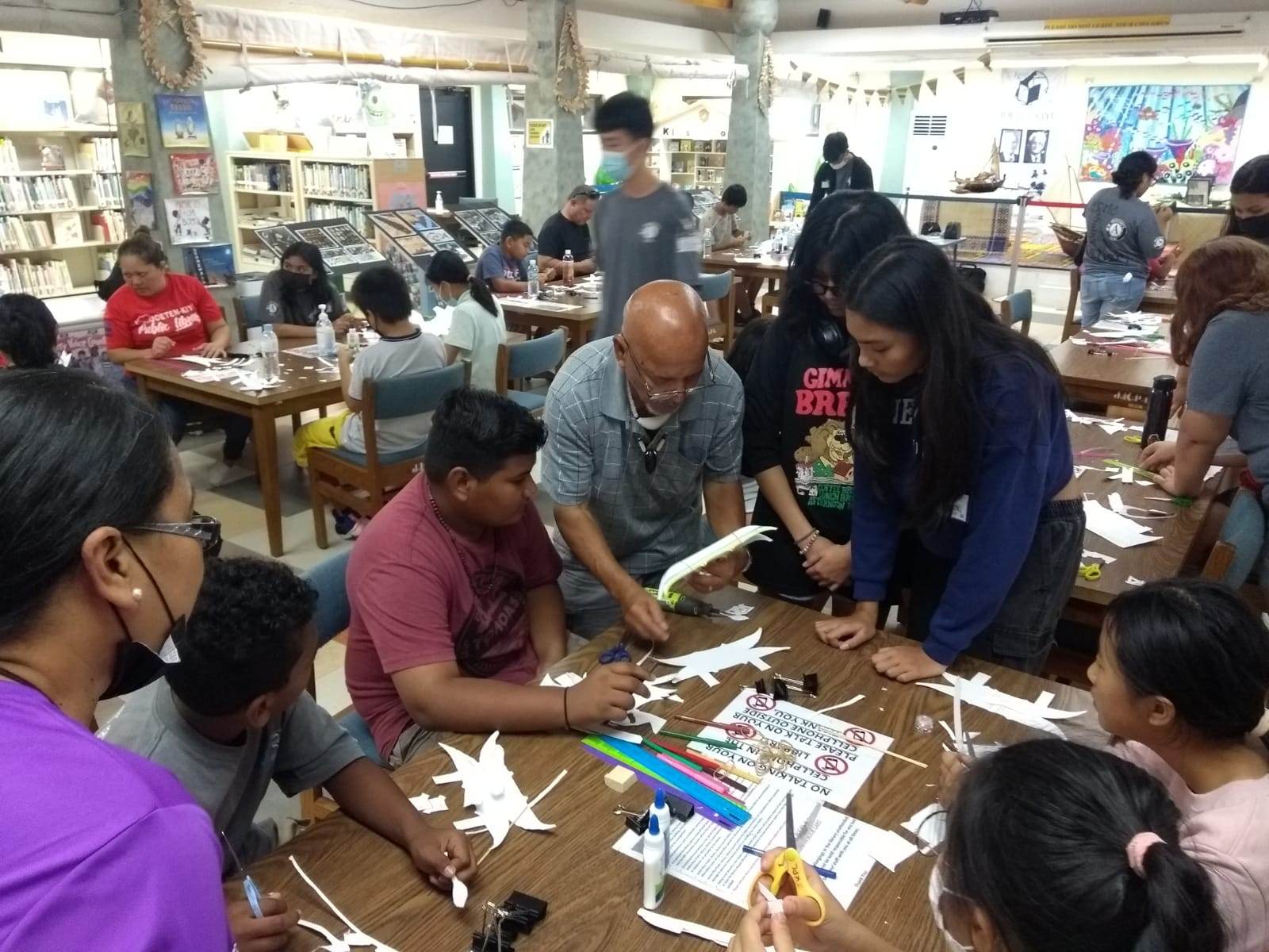 Children learn how to make an outrigger canoe using basic paper-based construction materials at the Joeten-Kiyu Public Library’s Children of Our Homeland Center on Feb. 18, 2023.