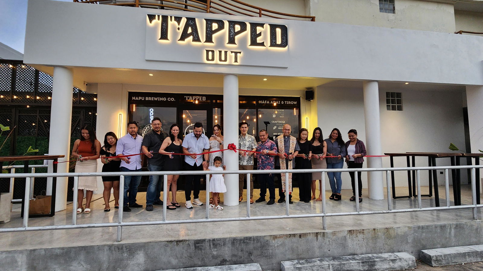 Tapped Out owners and personnel with their family members and Bishop Ryan Jimenez cut the ceremonial ribbon on Saturday evening, March 18, 2023.