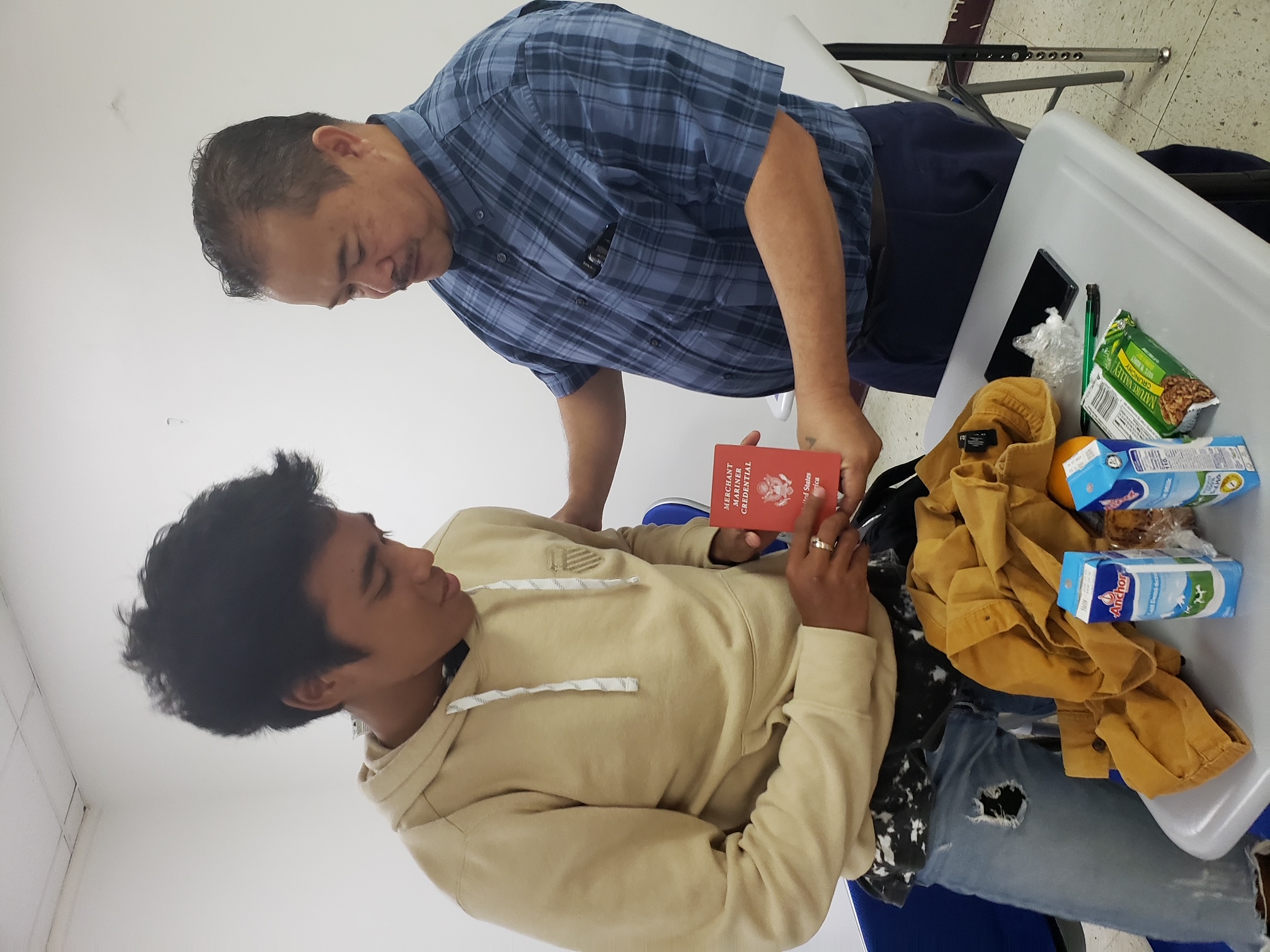Midshipman Kenshiro Yanai proudly presents his Merchant Marine Credential to Education Commissioner Dr. Alfred Ada.