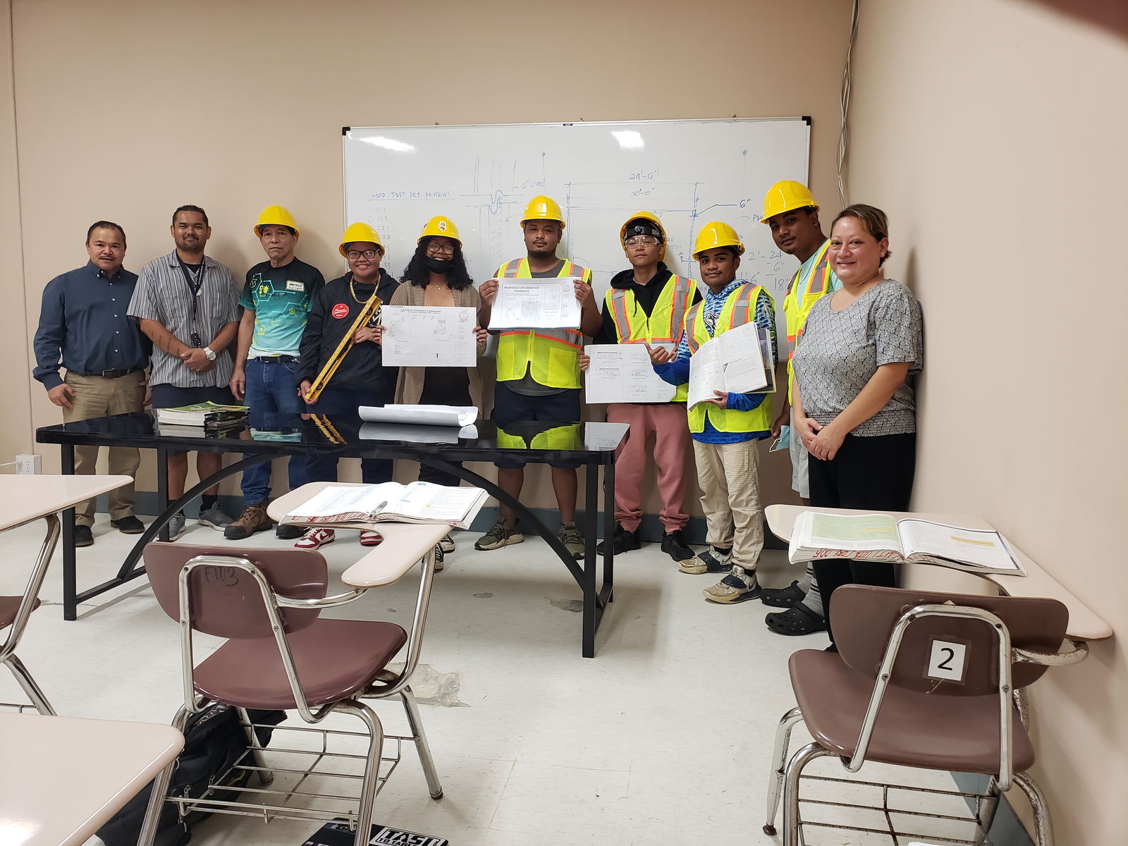 Commissioner of Education Dr. Alfred Ada and Director of Career & Technical Education Dr. Jessica Taylor pose for a photo with Da’ok Academy students participating in the Trading Up: Construction Craft Laborer program at NMTech campus in Lower Base.