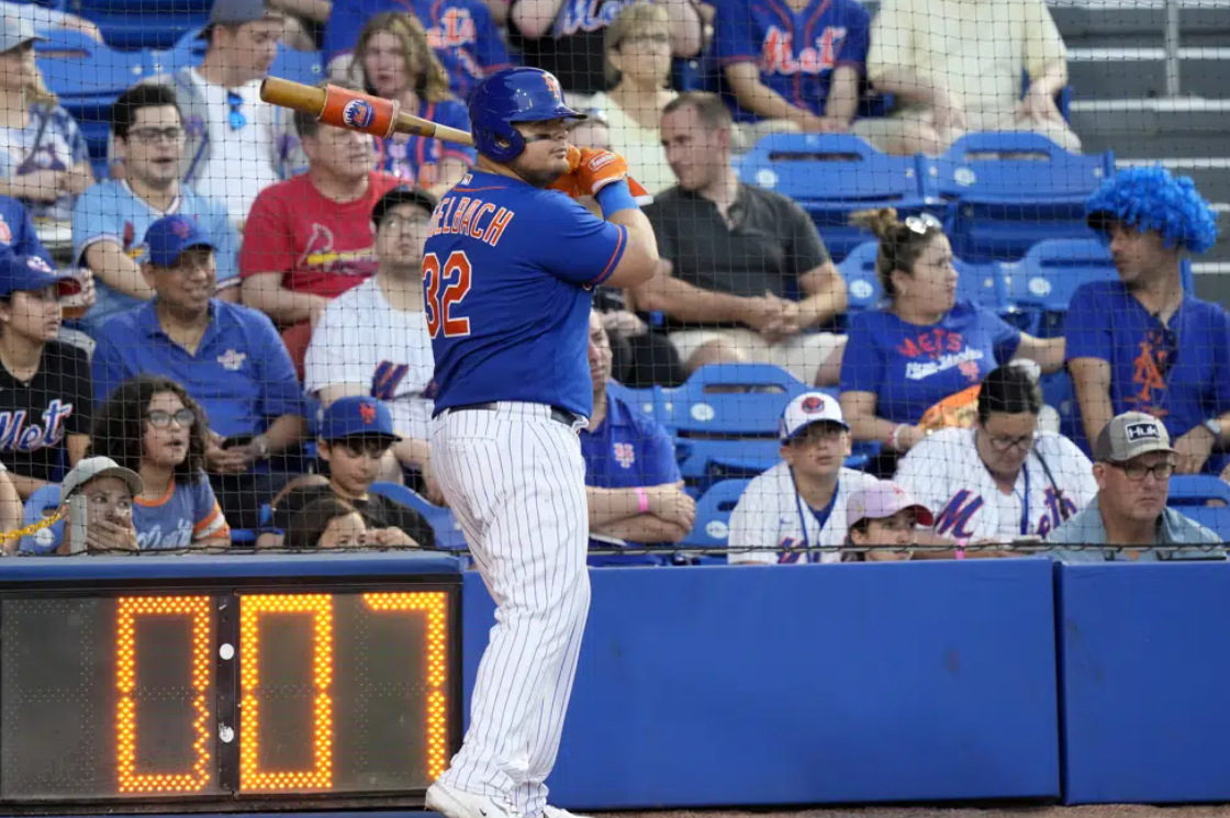 The pitch clock runs as New York Mets' Daniel Vogelbach (32) warms up on deck during the fifth inning of a spring training baseball game against the St. Louis Cardinals, Saturday, March 25, 2023, in Port St. Lucie, Fla.