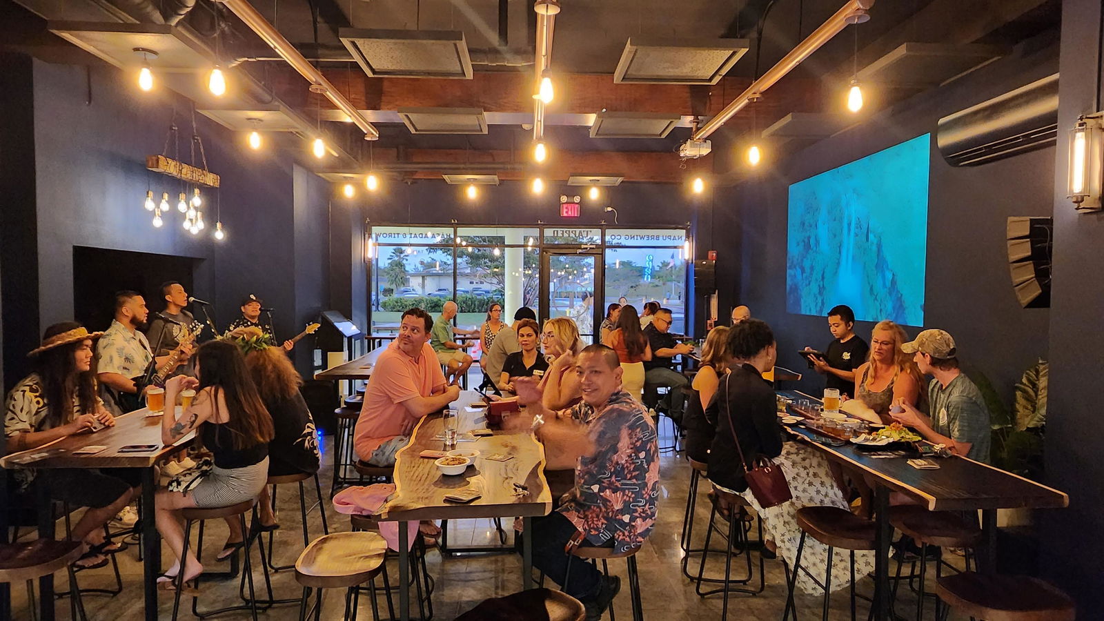 Community members enjoy the locally brewed craft beer and savory appetizers at Tapped Out on Saturday evening.