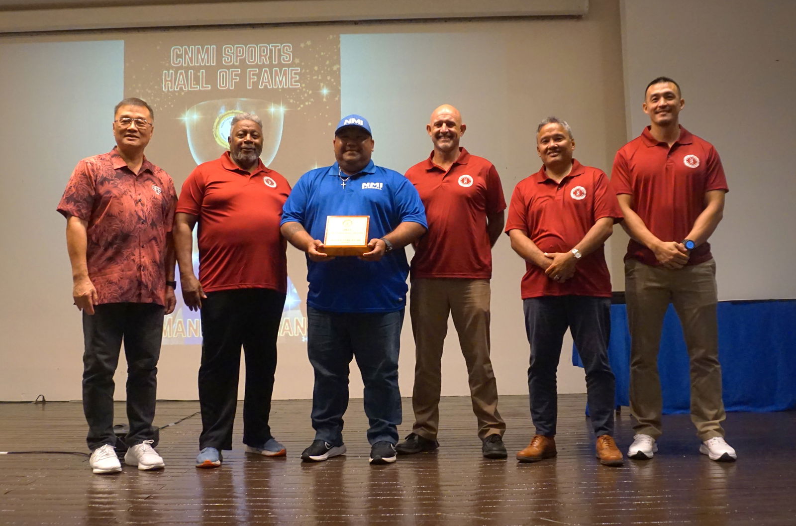 Manny Sablan, 3rd left,  holds the CNMI Sports Hall of Fame plaque as he poses for a photo with the Northern Marianas Sports Association board members and president Jerry Tan, left, during the NMSA awards banquet Tuesday at the Hibiscus Hall of Crowne Plaza Resort Saipan.