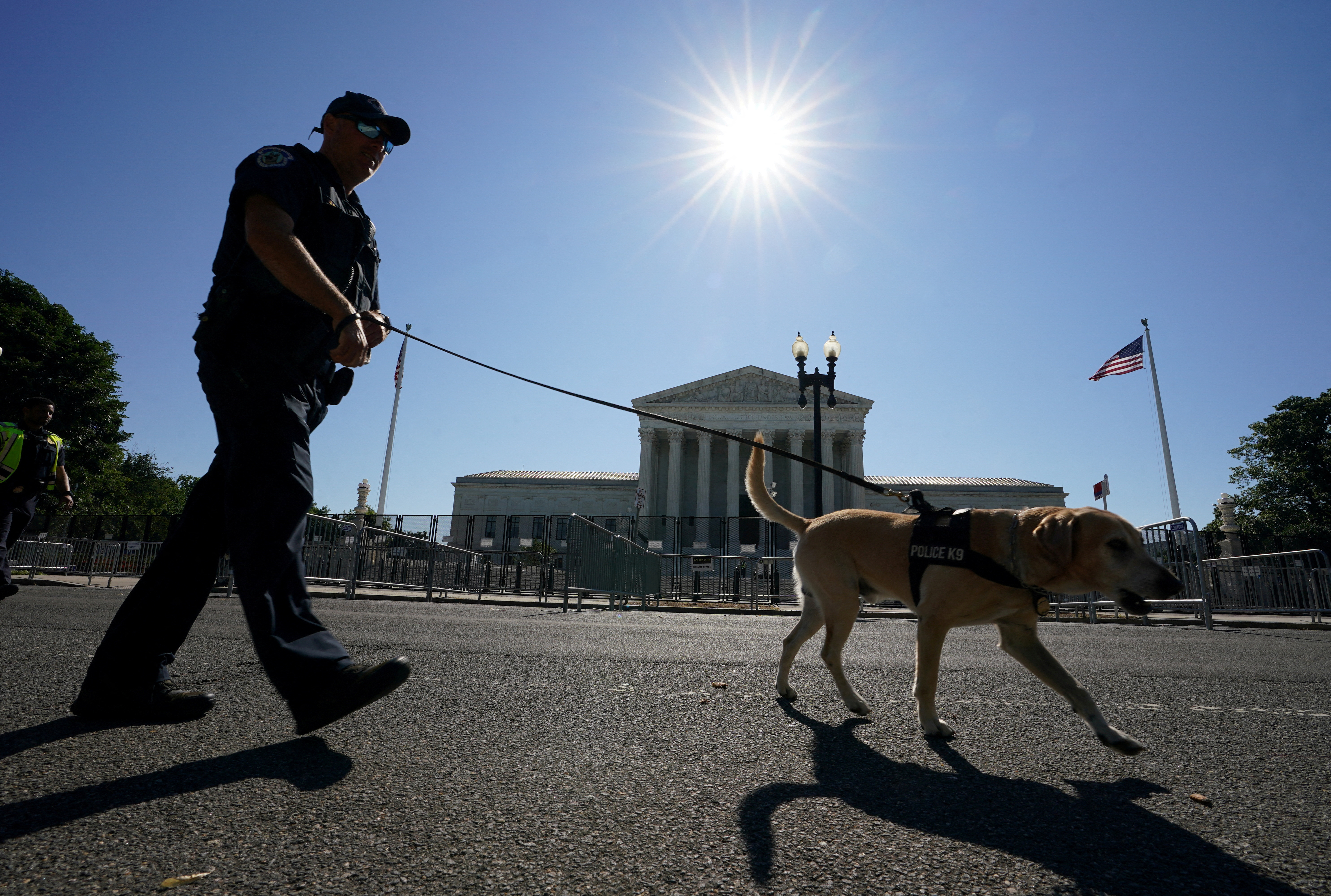 A police officer patrols with his K9 in front of the U.S. Supreme Court in Washington, D.C., June 29, 2022.