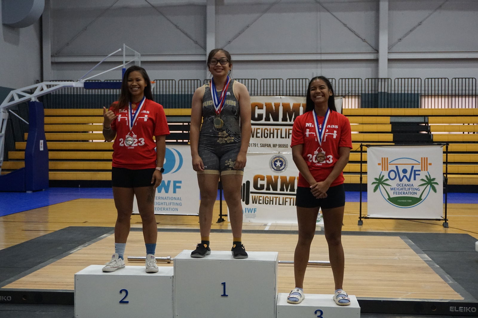 Nissi Lujan, center, Devine Pua, left, and Katie Camacho pose  with their medals in the open division 64kg weight class of the Marianas Cup 2023 Saturday at the Ada gym.