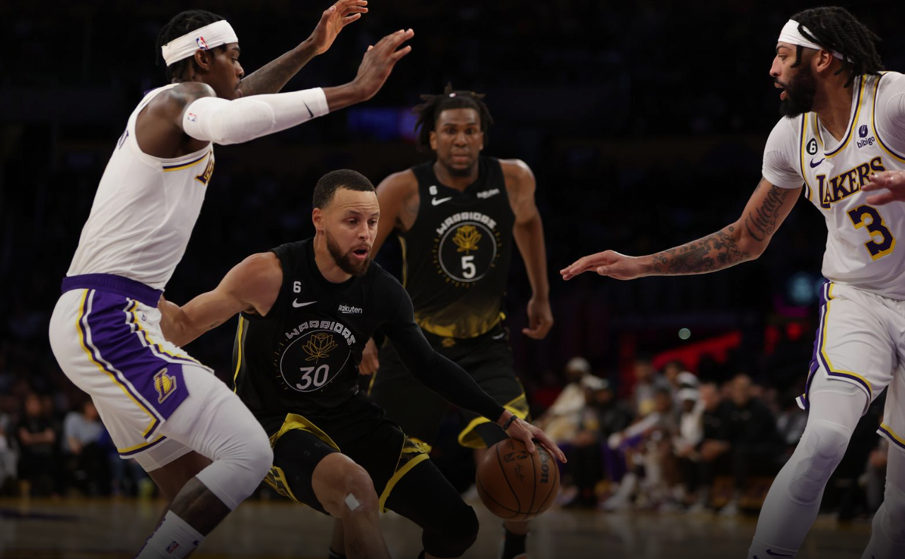 Golden State Warriors guard Stephen Curry (30) dribbles the ball between Los Angeles Lakers forward Jarred Vanderbilt (2) and forward Anthony Davis (3) during the second quarter at Crypto.com Arena in Los Angeles, California, March 5, 2023.