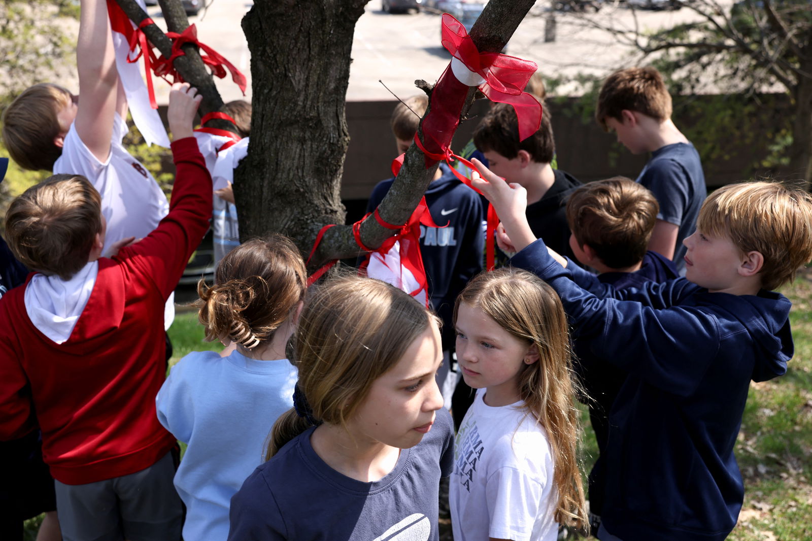 Children from St. Paul Christian Academy across the street tie ribbons to a tree in remembrance after a deadly shooting at The Covenant School in Nashville, Tennessee, March 28, 2023.