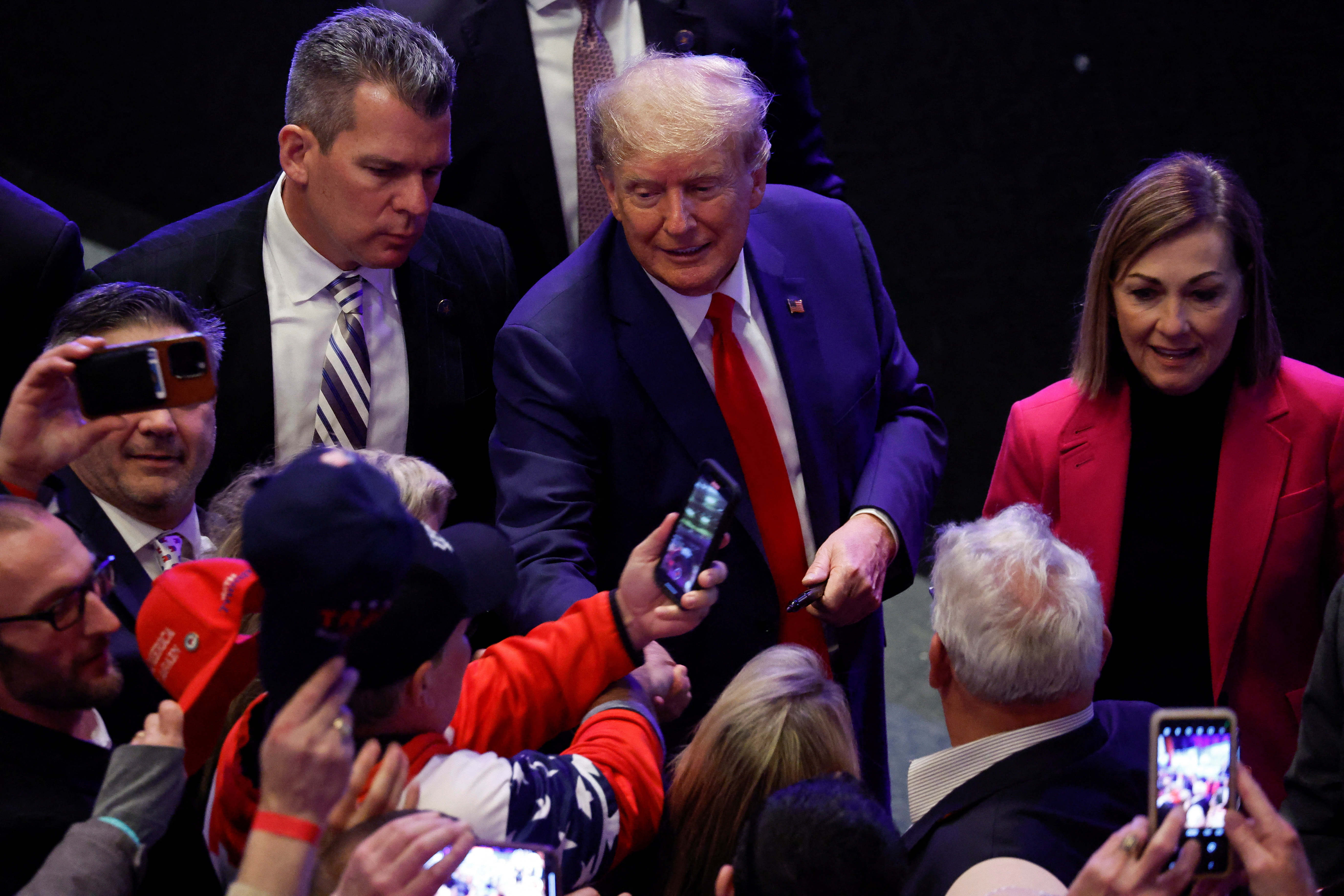 Former President Donald Trump greets supporters accompanied by Iowa Governor Kim Reynolds during a campaign rally, in Davenport, Iowa, March 13, 2023.