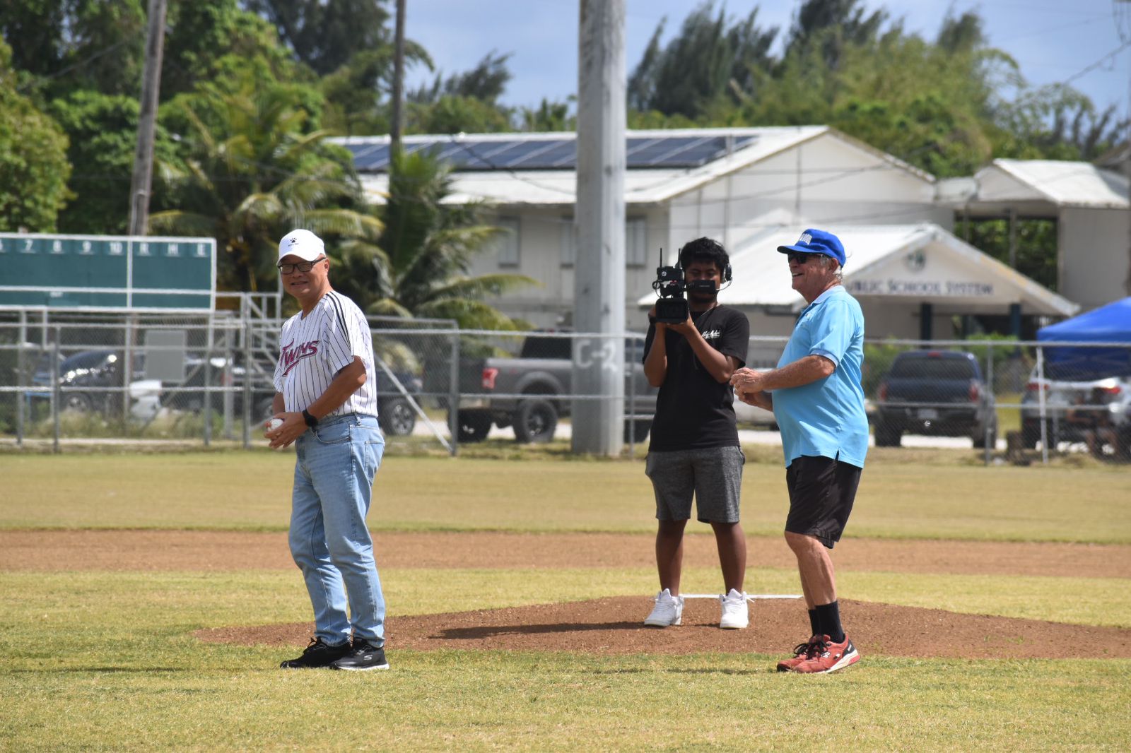 Jerry Tan, left, and Bob Coldeen, right, prepare for the ceremonial first pitch of the Tan Holdings Saipan Baseball League at the "Tan Ko" Palacios Baseball Field on Saturday.