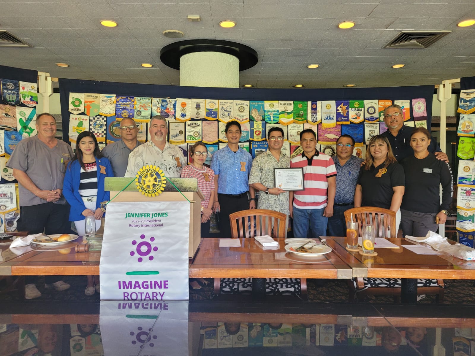 Acting Department of Public Works Secretary Ray N. Yumul, sixth right, holds a plaque of appreciation as he poses for a photo with Rotary Club of Saipan President Wendell Posadas, sixth left, and other Rotarians after a presentation at the Hyatt Regency Saipan's Giovanni's Restaurant on Tuesday.