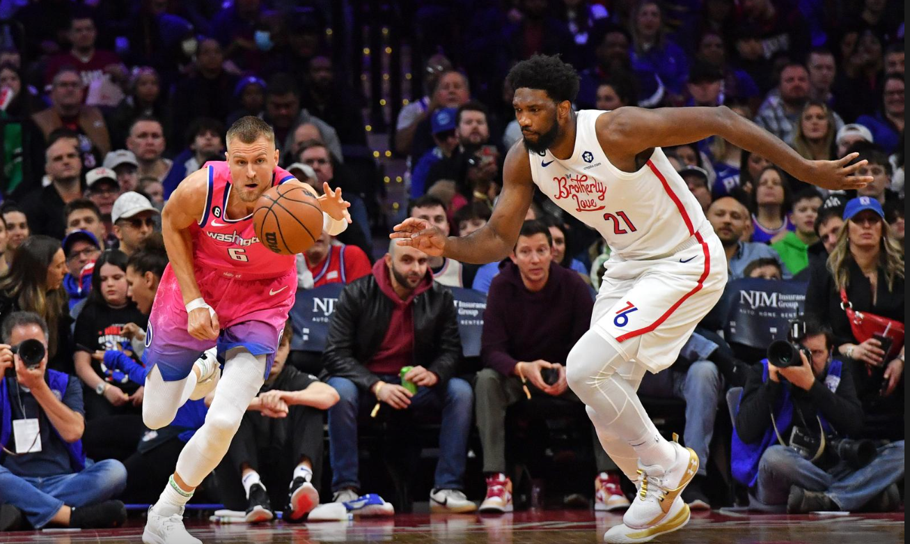 Washington Wizards center Kristaps Porzingis (6) and Philadelphia 76ers center Joel Embiid (21) chase after the loose ball during the first quarter at Wells Fargo Center in Philadelphia, Pennsylvania, March 12, 2023.